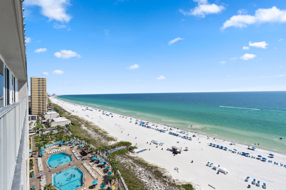 The Summit Penthouse 1501 – View from penthouse showing pools, beach chairs, and ocean.