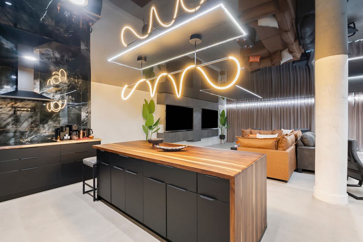 The Summit Penthouse 1501 – Modern kitchen and living area with stylish lighting, dark cabinetry, and comfortable seating.