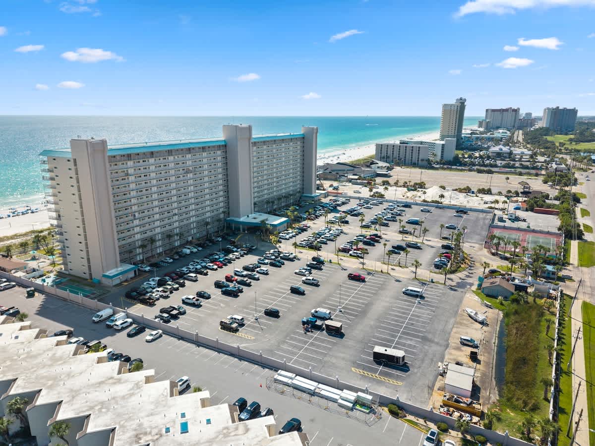 The Summit Penthouse 1501 – Aerial view of The Summit Penthouse 1501, beachfront, with surrounding parking and nearby buildings.