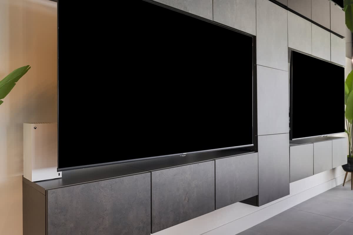 The Summit Penthouse 1501 – Stylish living room with wall-mounted TVs and a large cabinet beneath.
