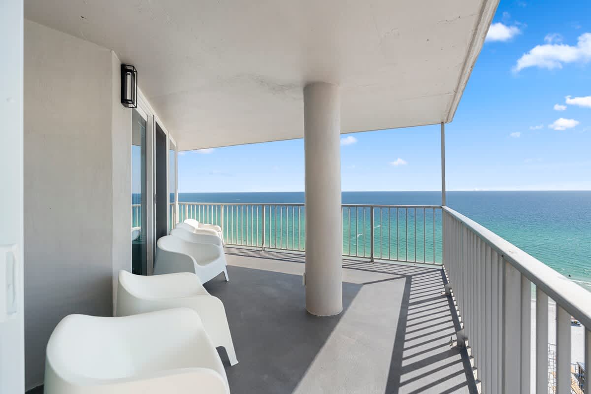 The Summit Penthouse 1501 – Balcony of penthouse with white chairs and ocean view.