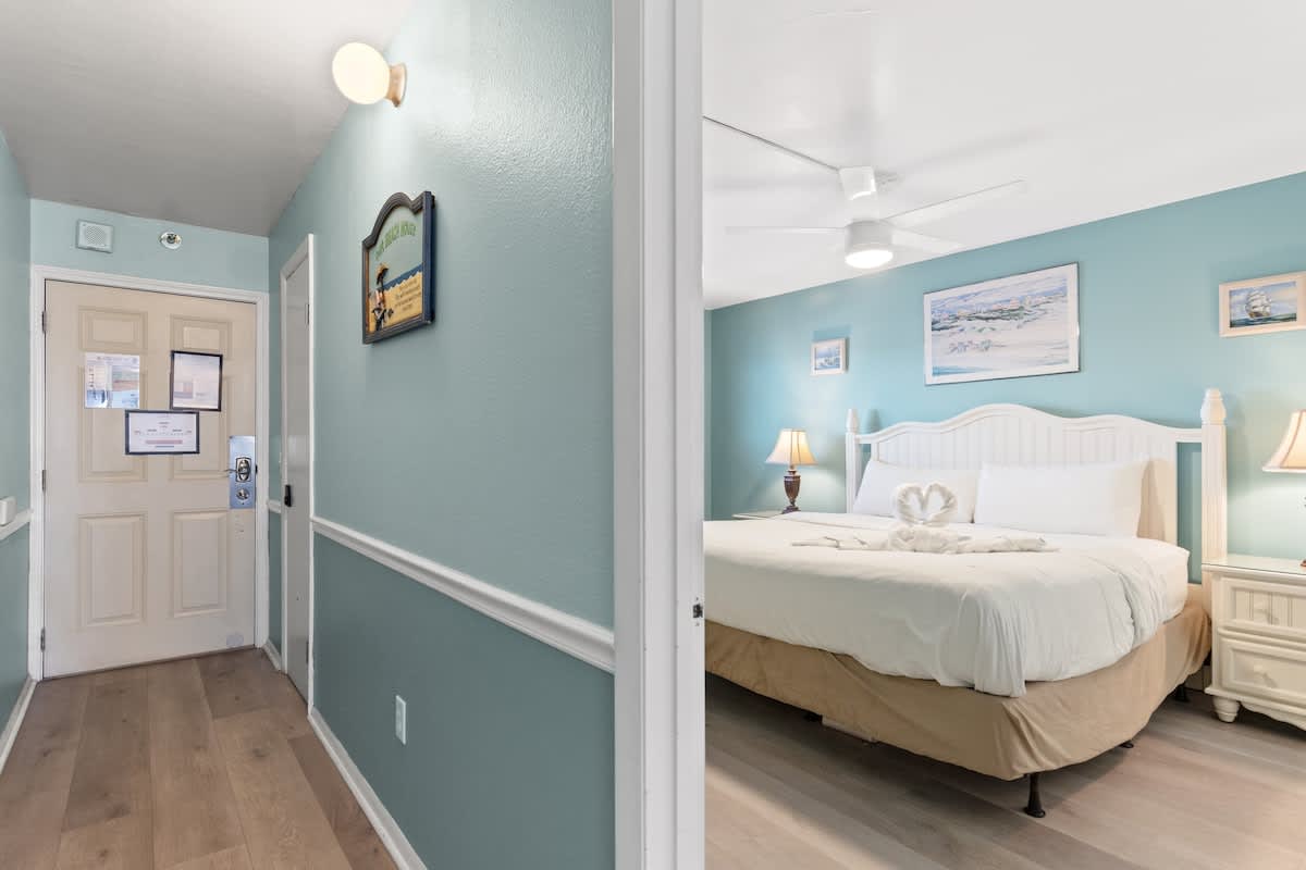 The Summit 315 – Entryway leading to a bedroom with a large bed, nightstand, and decorative wall art.