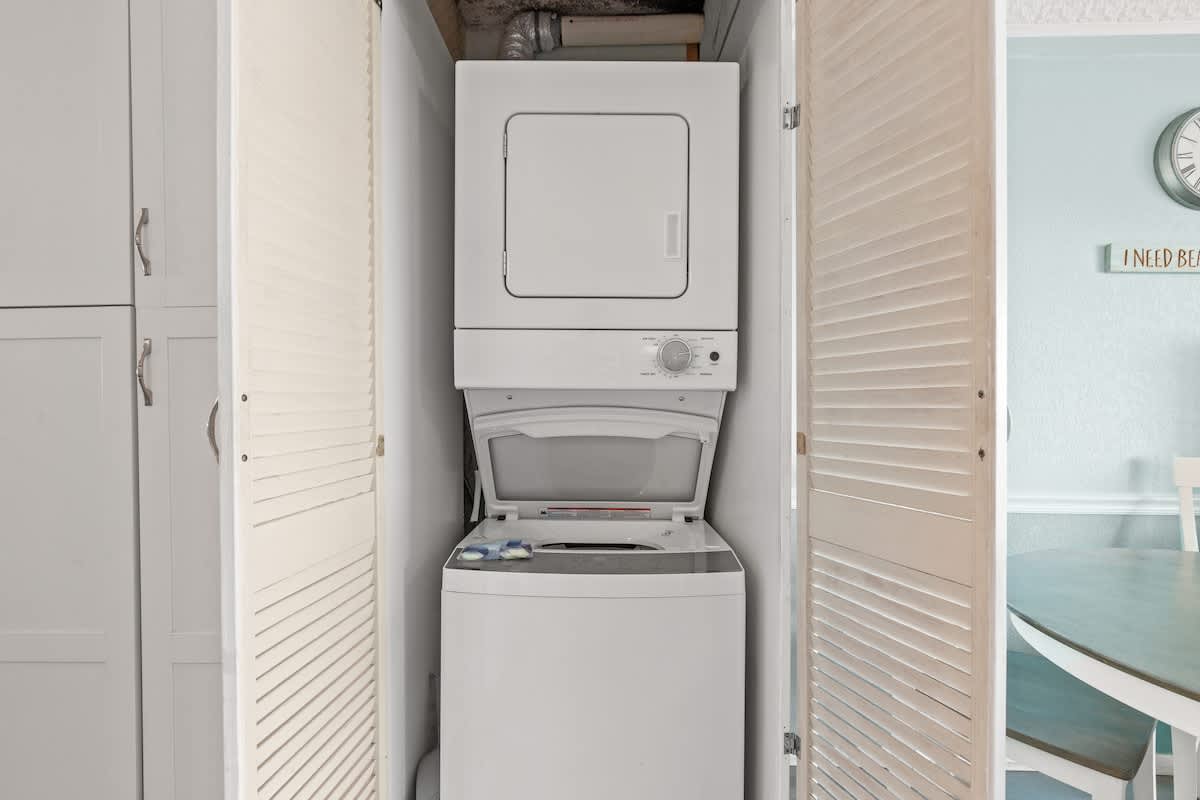 The Summit 315 – Washer and dryer in a closet, with light blue walls and a dining space visible in the background.