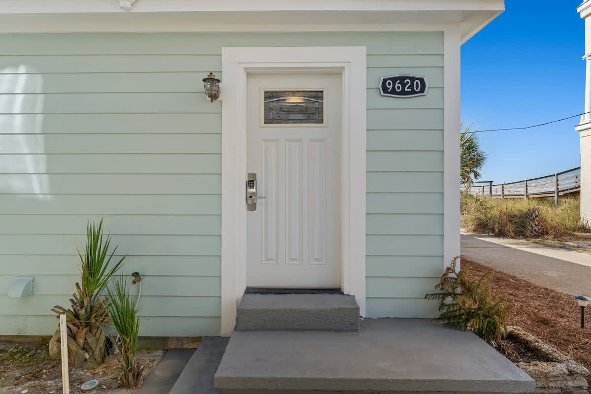 9620 Beach Blvd – Mint green exterior with a porch step, front door, and house number 9620.