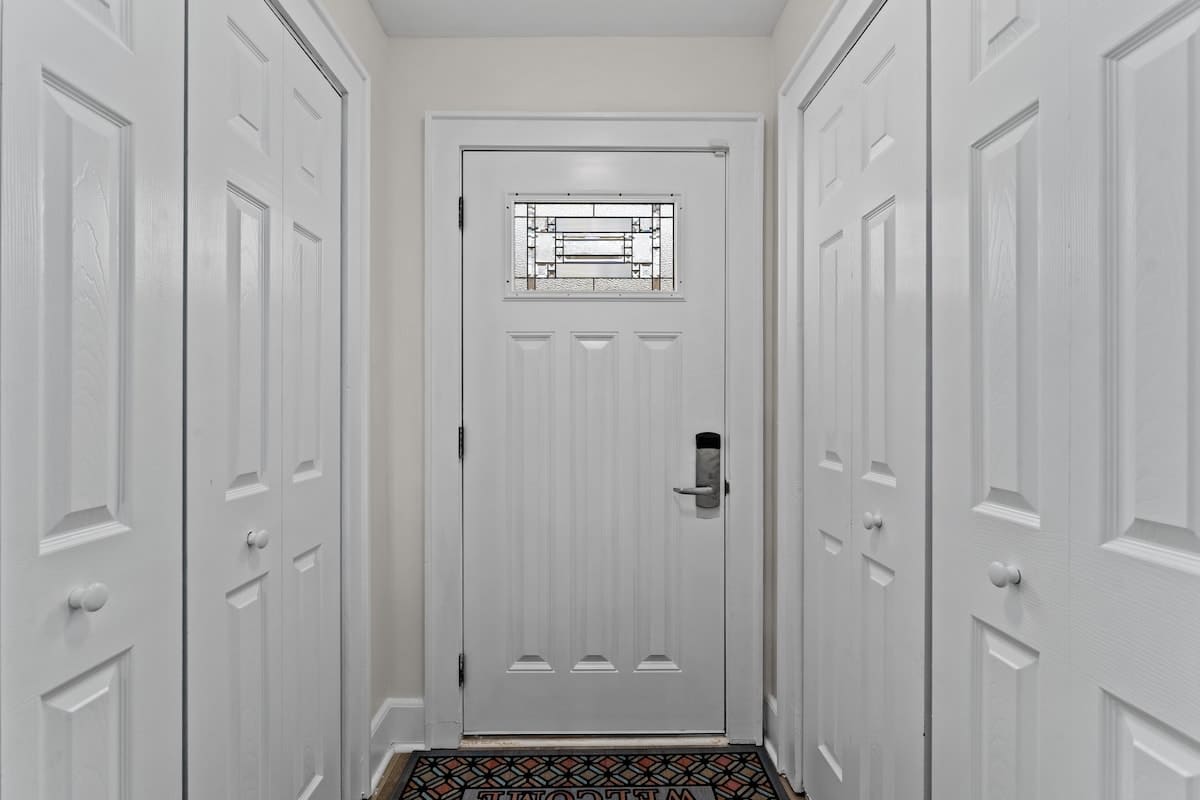 9620 Beach Blvd – Entryway with white walls, closet doors, and a door featuring a stained glass window.