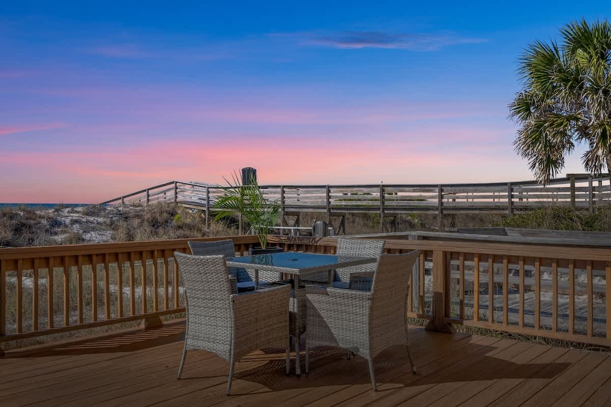 9620 Beach Blvd – Outdoor deck with a table and chairs, view of beach access path and sunset sky.