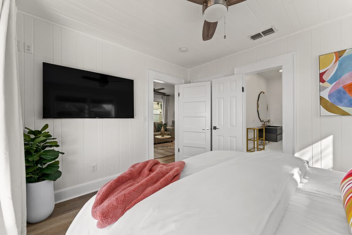 9620 Beach Blvd – Cozy bedroom featuring a TV, a plant, and an en-suite bathroom entrance.
