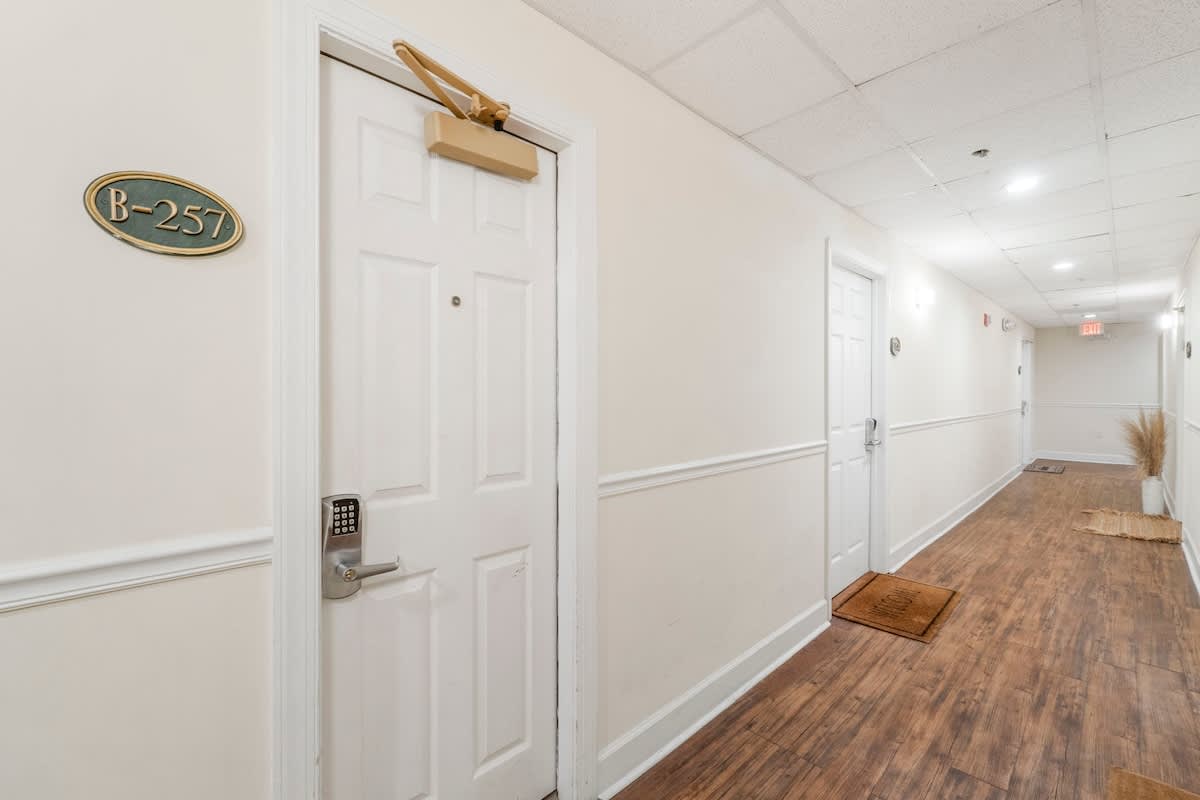 Village of SW B257 – Hallway view with door labeled B-257 and wooden flooring.