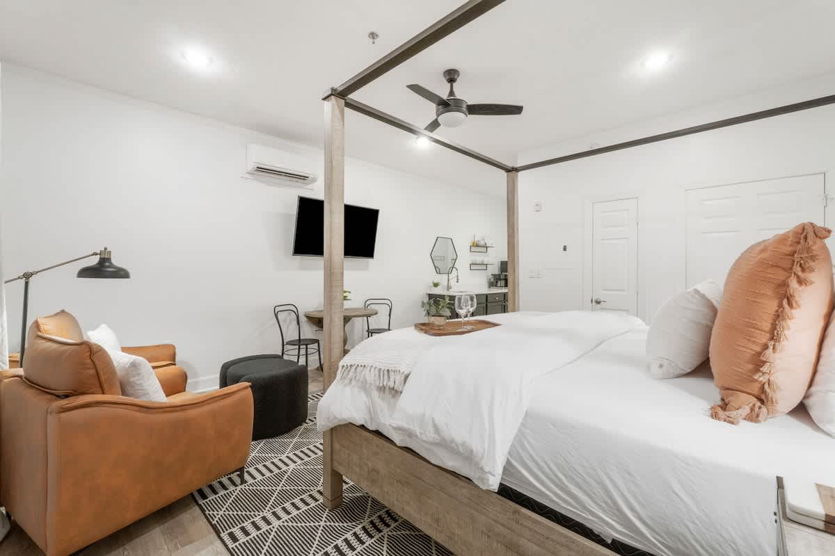 Village of SW B257 – Cozy bedroom with a four-poster bed, seating area, and kitchenette.