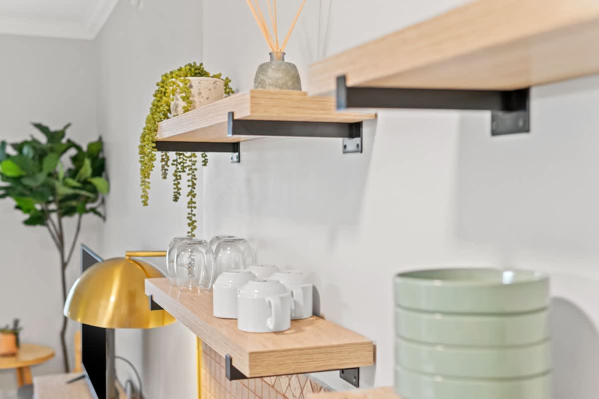 Village of SW B203 – Modern living space with wooden shelves, glassware, and decorative plants.