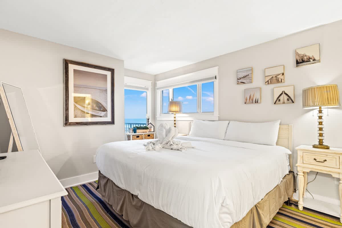 The Summit 301 – Cozy bedroom with a large bed, ocean view, and decorative artwork on the walls.