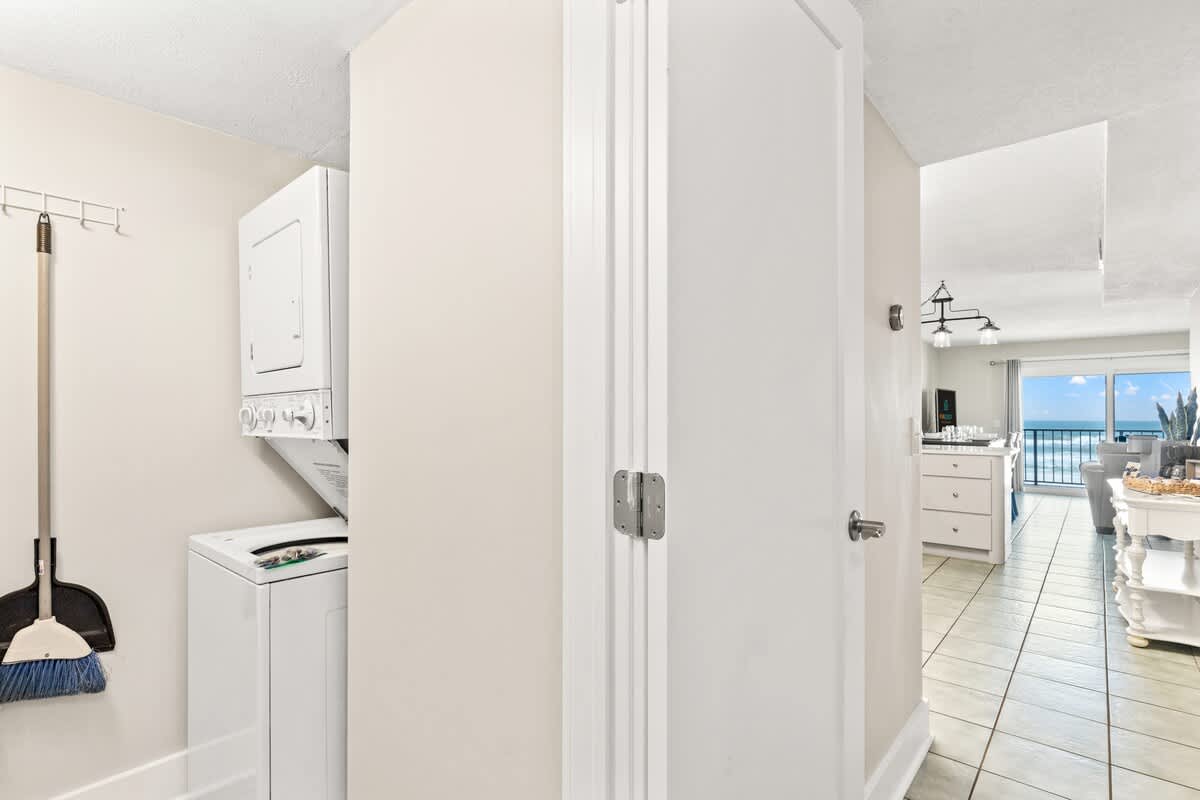 The Summit 301 – Laundry area with washer and dryer, view of ocean through open living room area.