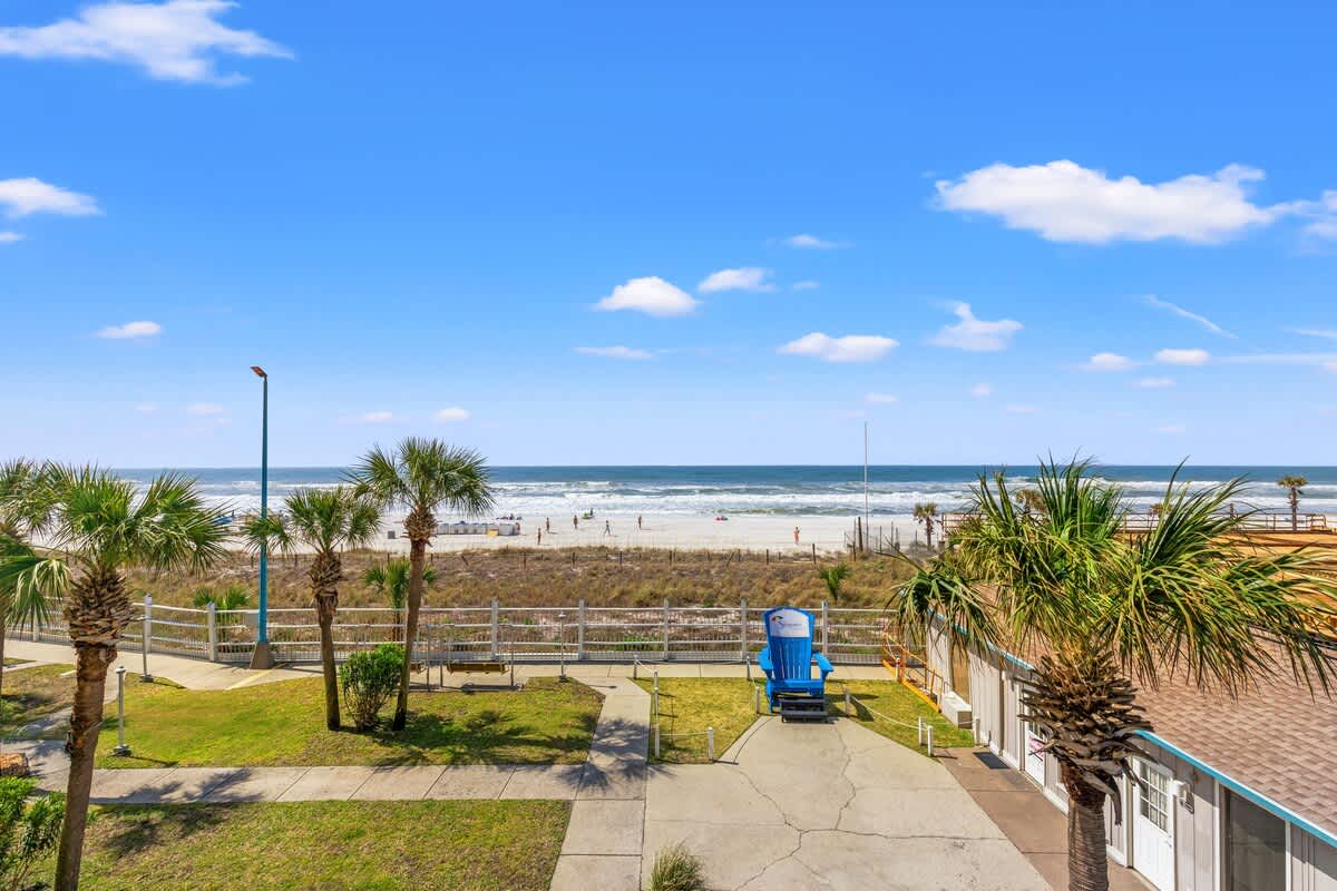 The Summit 301 – Ocean view from patio with palm trees and beach access.