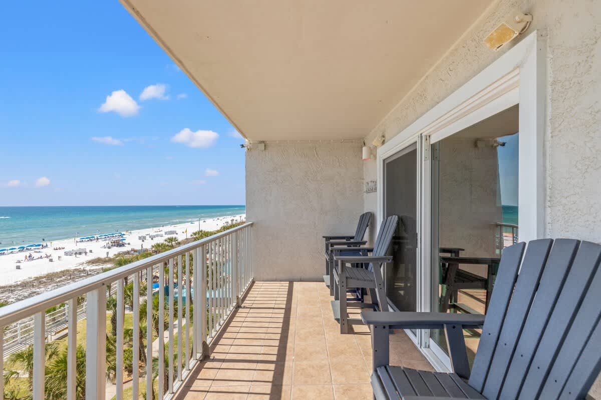 The Summit 632 – Oceanfront balcony with four chairs, overlooking the beach and turquoise water.