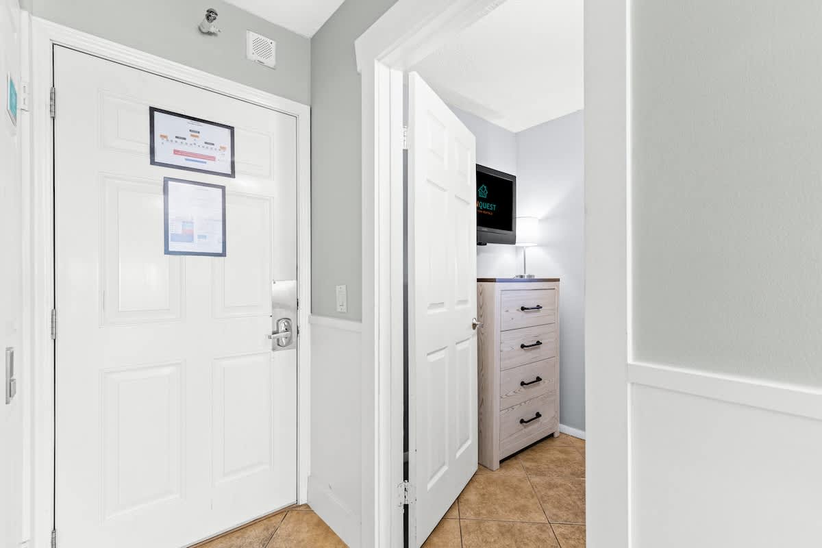 The Summit 632 – Entryway with two doors, a dresser, TV, and light fixture.
