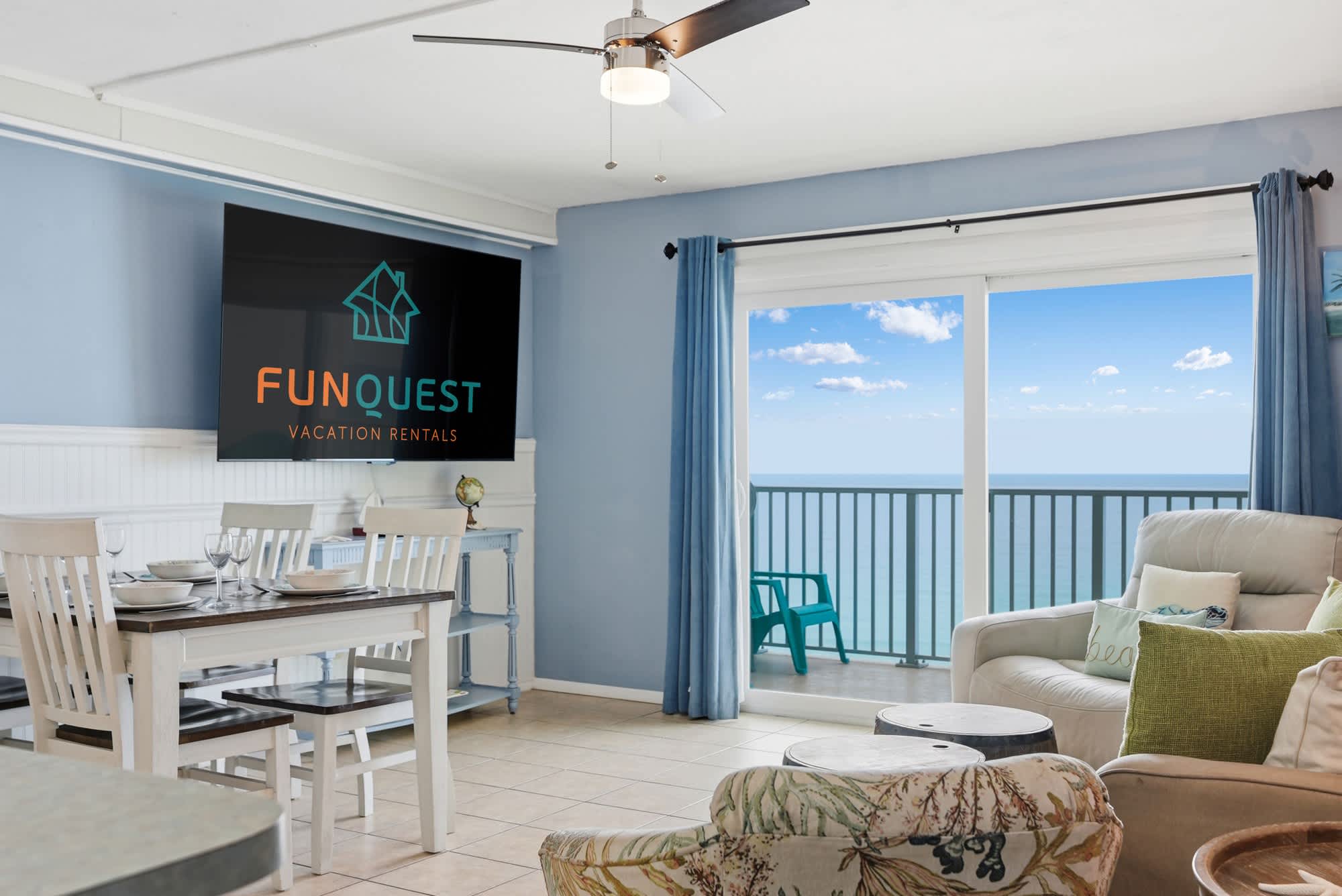 The Summit 1421 – Living room with ocean view, dining area, and large TV.