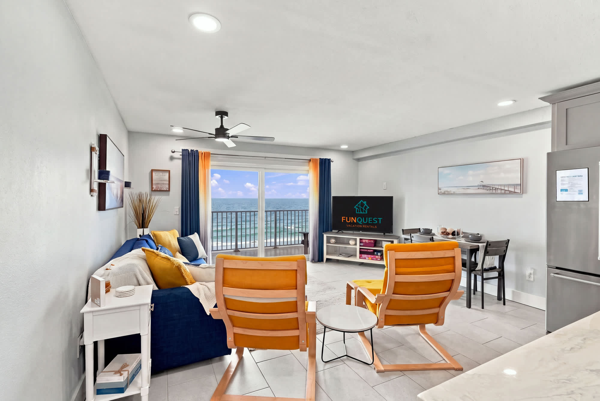 The Summit 1122  – Living room with ocean view, couch, two yellow chairs, dining table, and TV.
