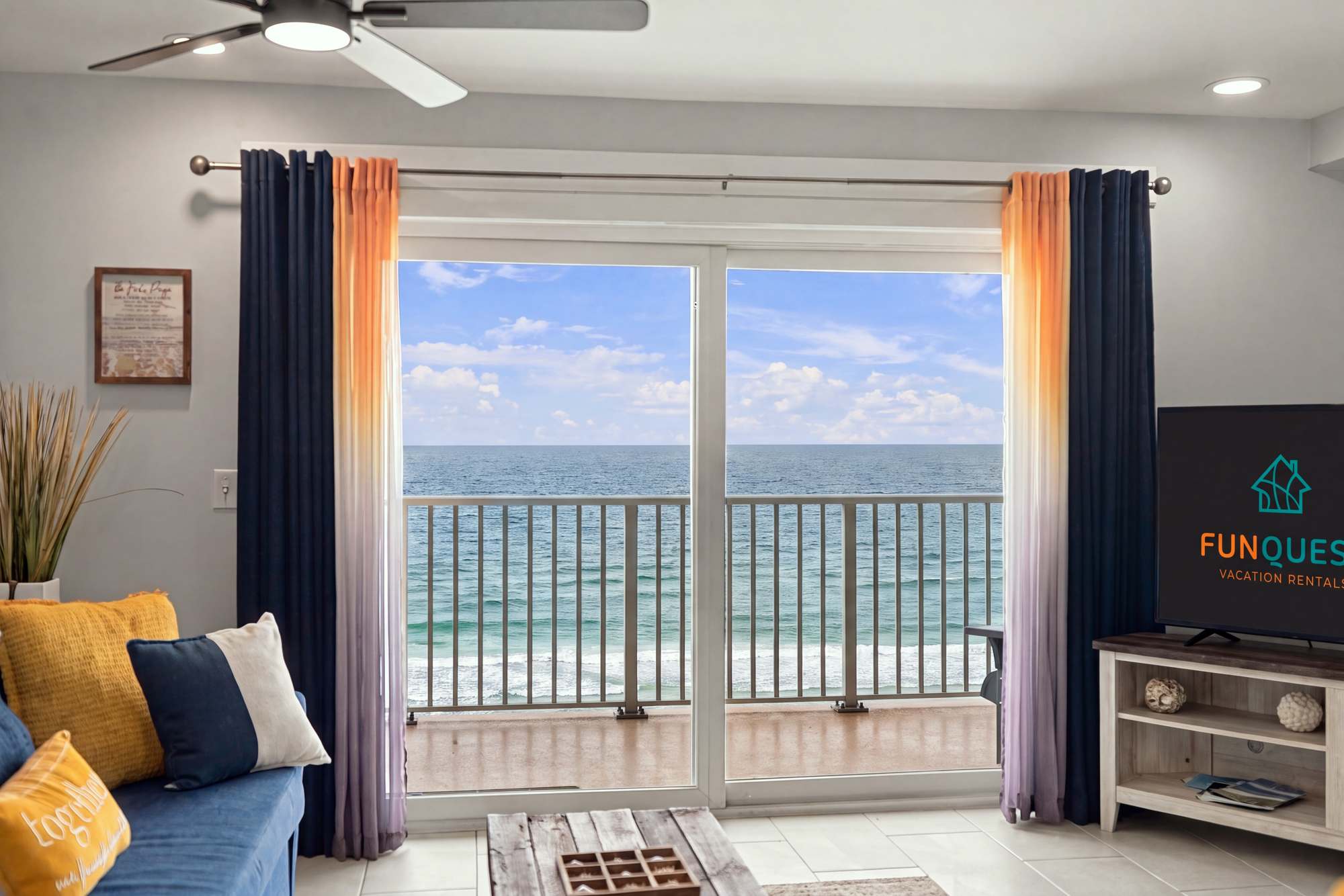 The Summit 1122  – Cozy living room with ocean view, sliding glass doors, and colorful curtains.