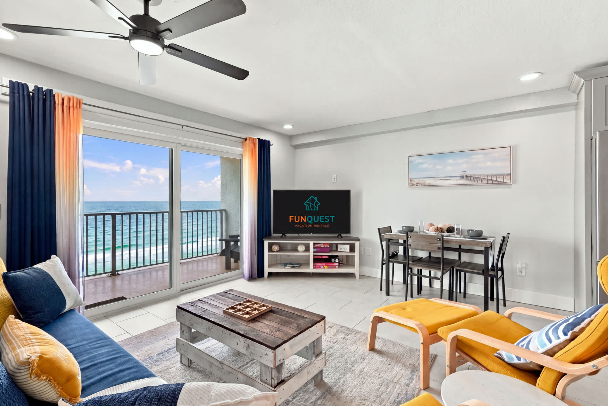 The Summit 1122  – Living room with ocean view, sofa, yellow chairs, dining table, and TV.