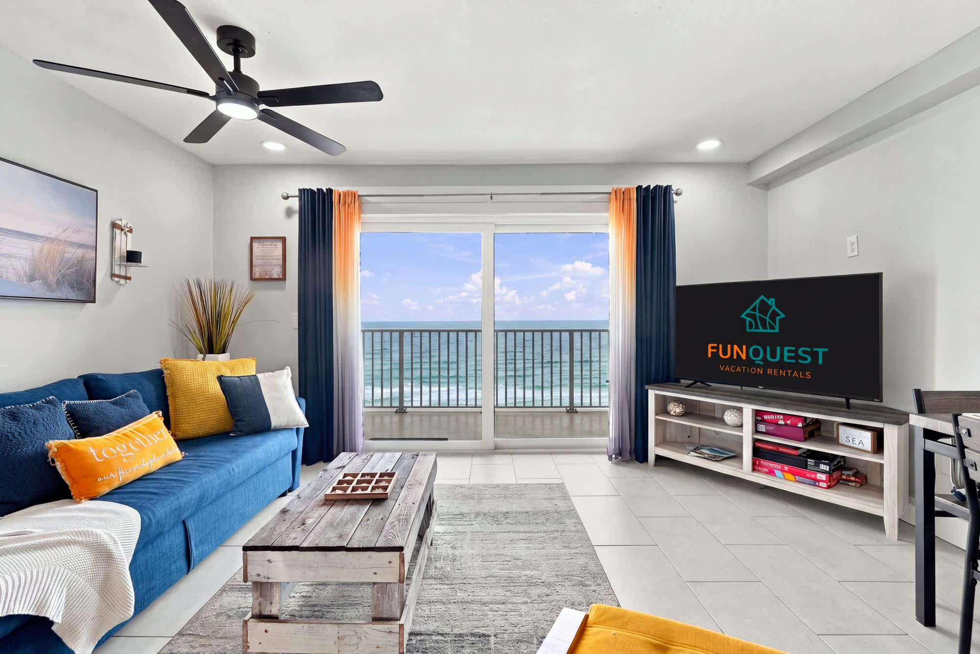The Summit 1122  – Living room with blue sofa, ocean view, and sliding glass door.