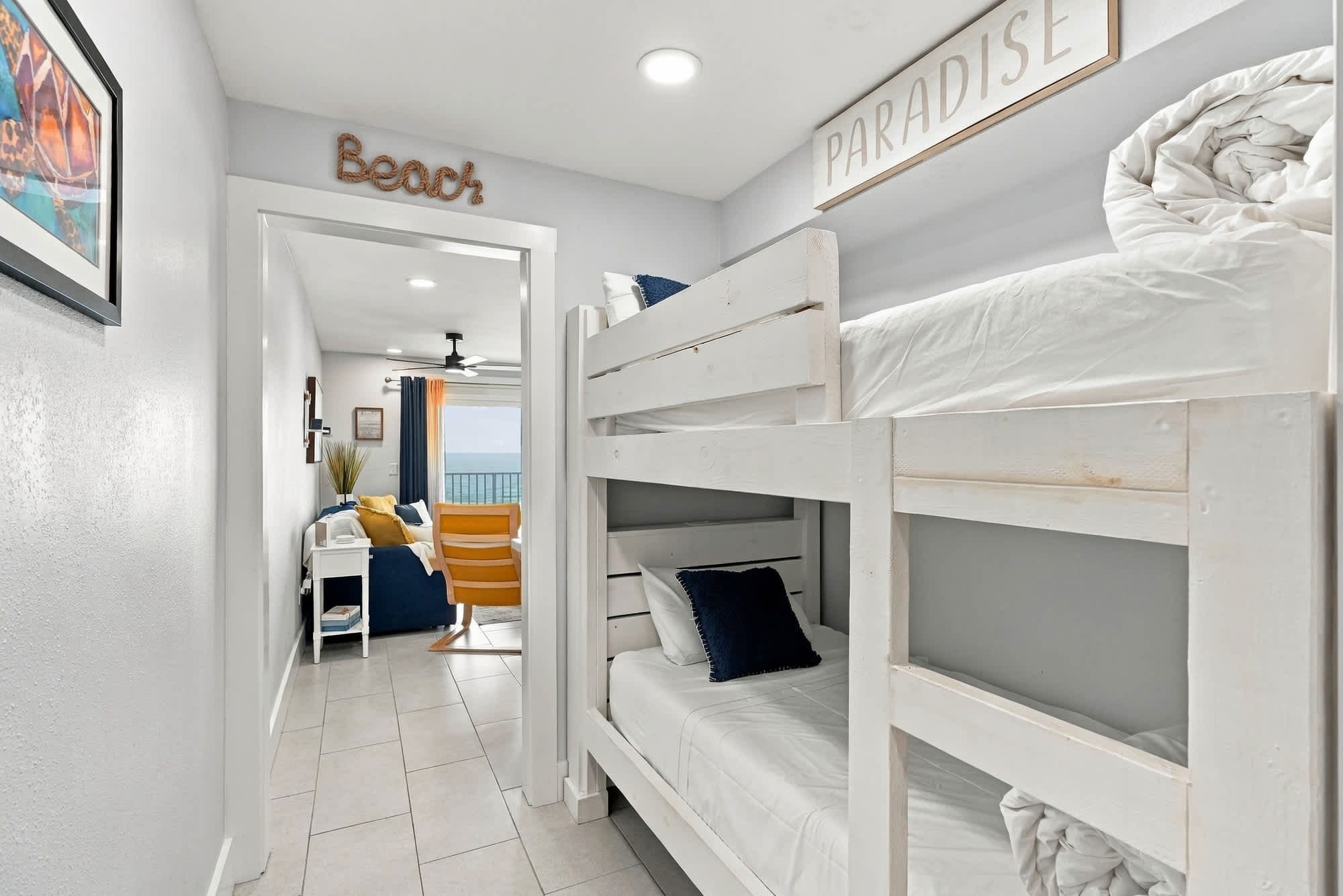 The Summit 1122  – Bunk beds in a hallway leading to a living area with ocean view and seating.
