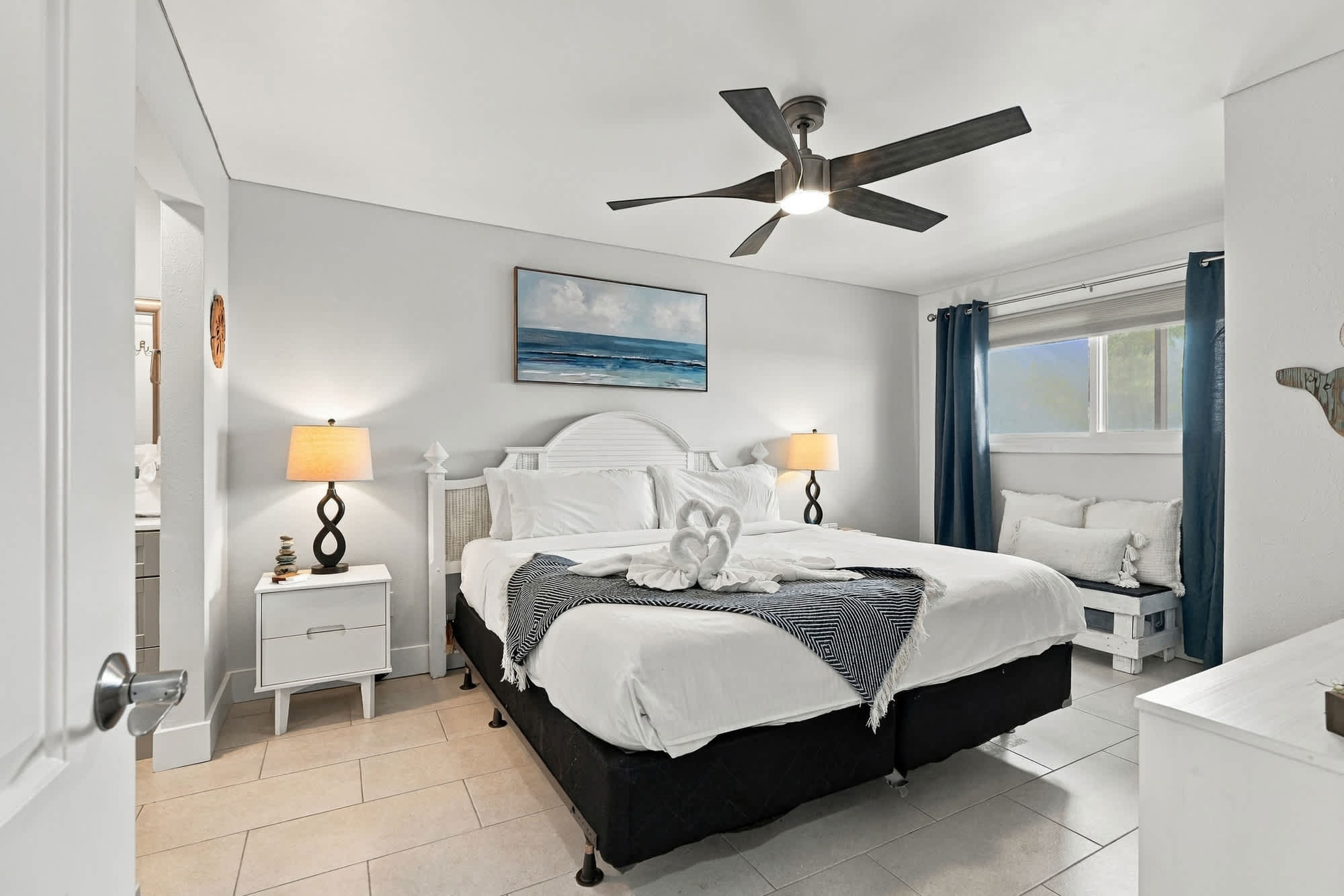 The Summit 1122  – Bedroom with king bed, bedside lamps, window seating, and ceiling fan.
