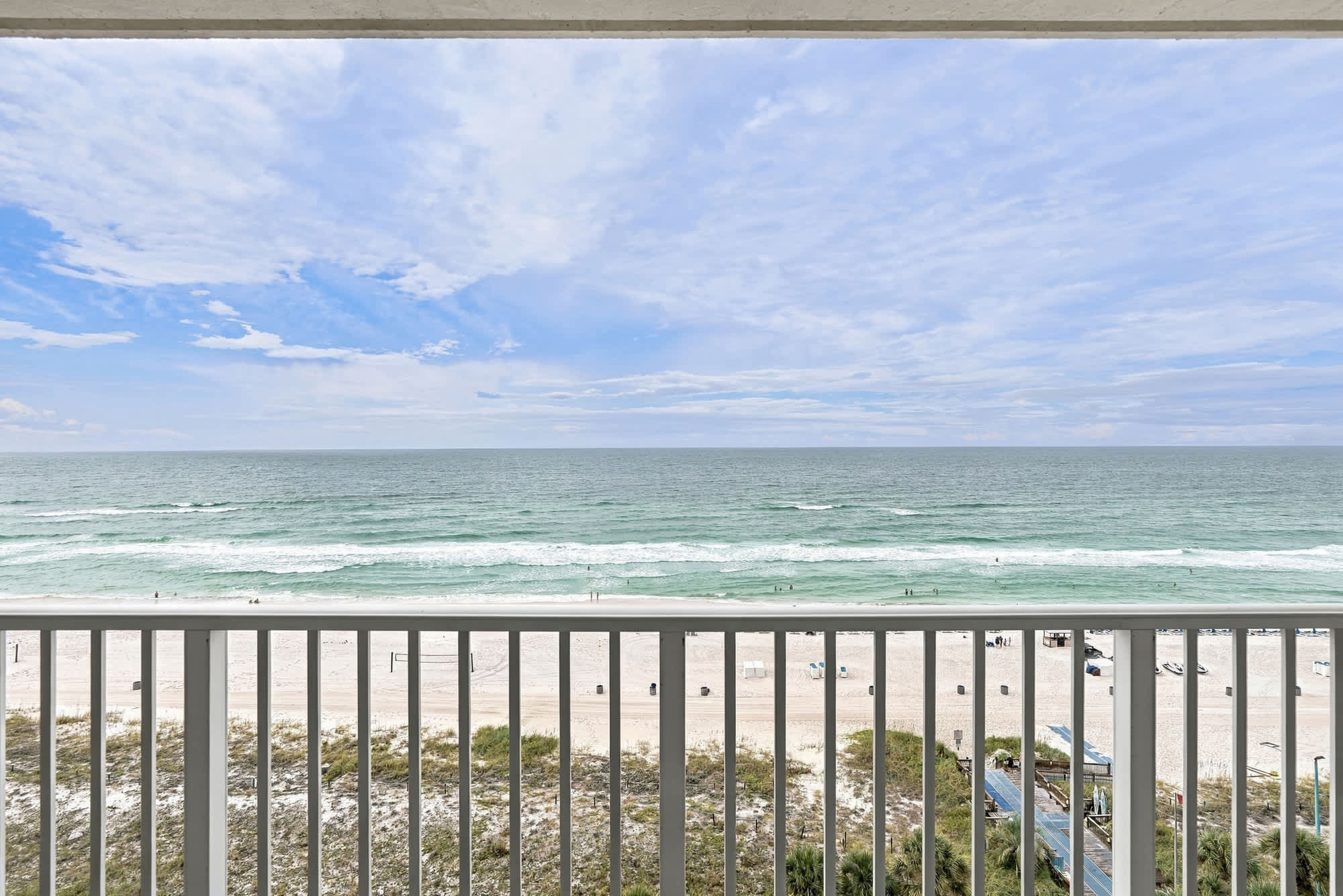 The Summit 1122  – View of the beach and ocean from a balcony, with sandy shoreline and waves.
