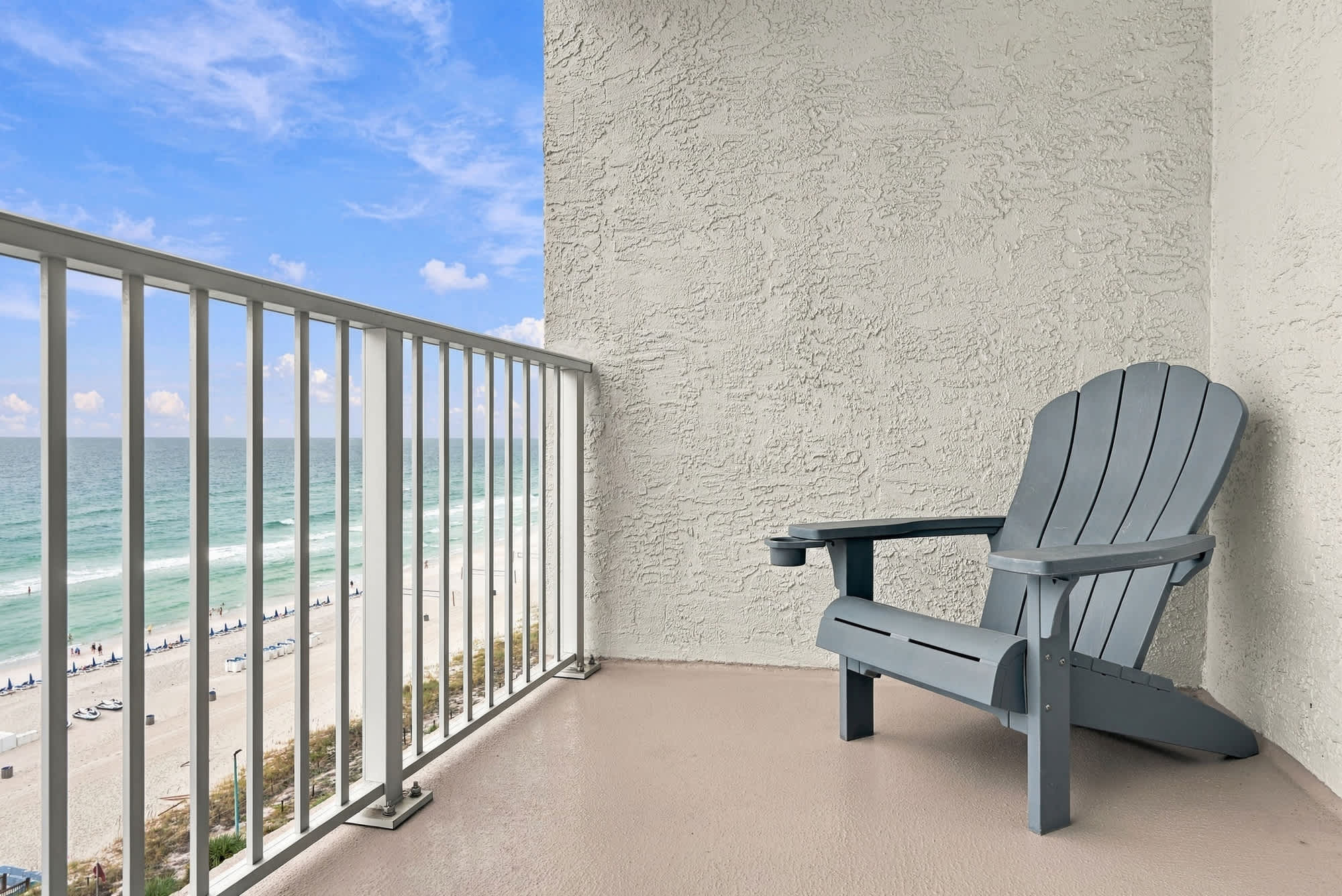 The Summit 1122  – Balcony with a gray adirondack chair overlooking the beach and ocean.