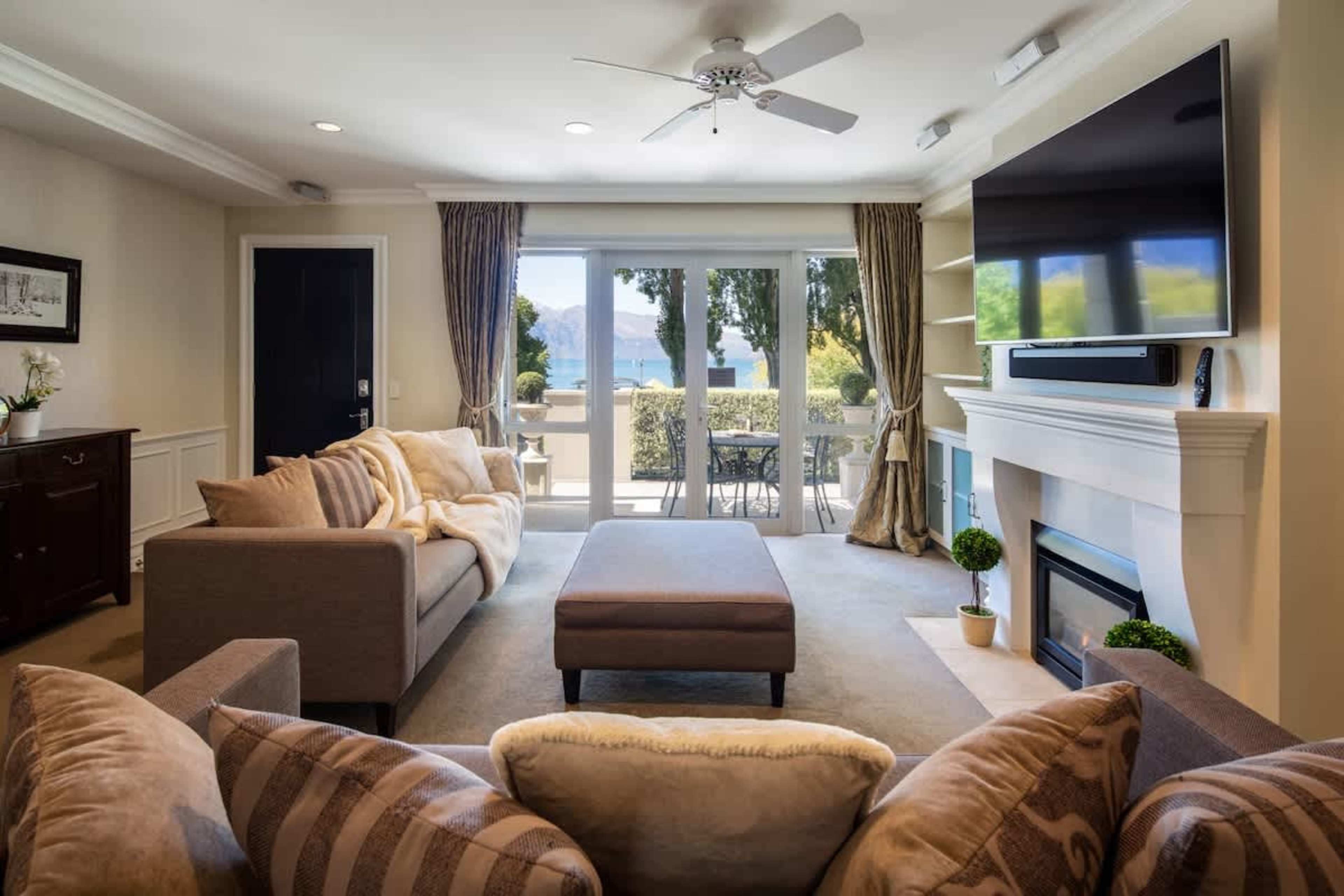Cozy Lakeview Living
Relax in the inviting living room with a warm gas fireplace and large windows offering glimpses of the lake, creating a peaceful retreat after exploring Queenstown.