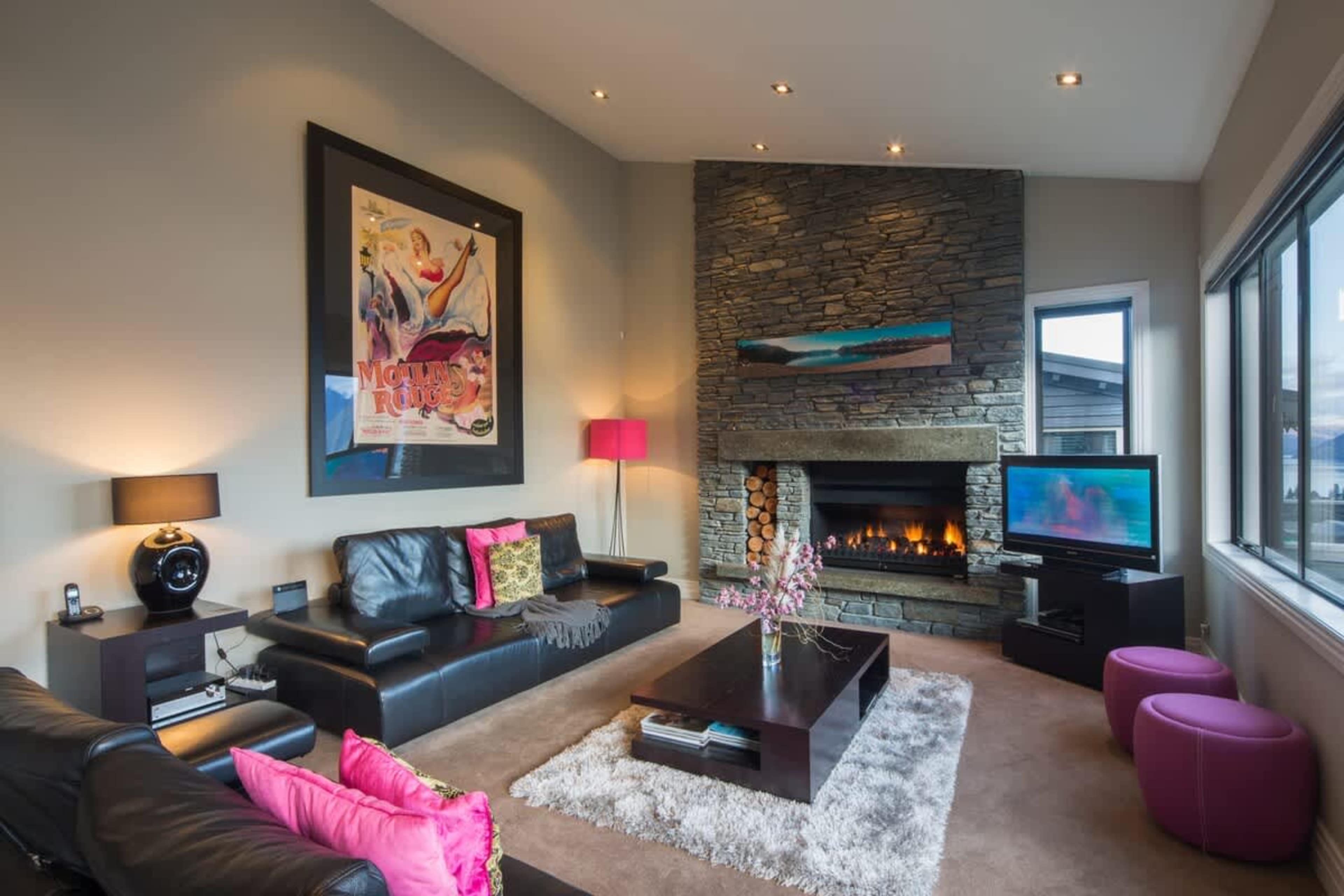 Elegant and Cozy Living Room: Relax by the warm gas fireplace, surrounded by stylish furnishings and panoramic views of Lake Wakatipu and the Remarkables. 
NZ luxury travel