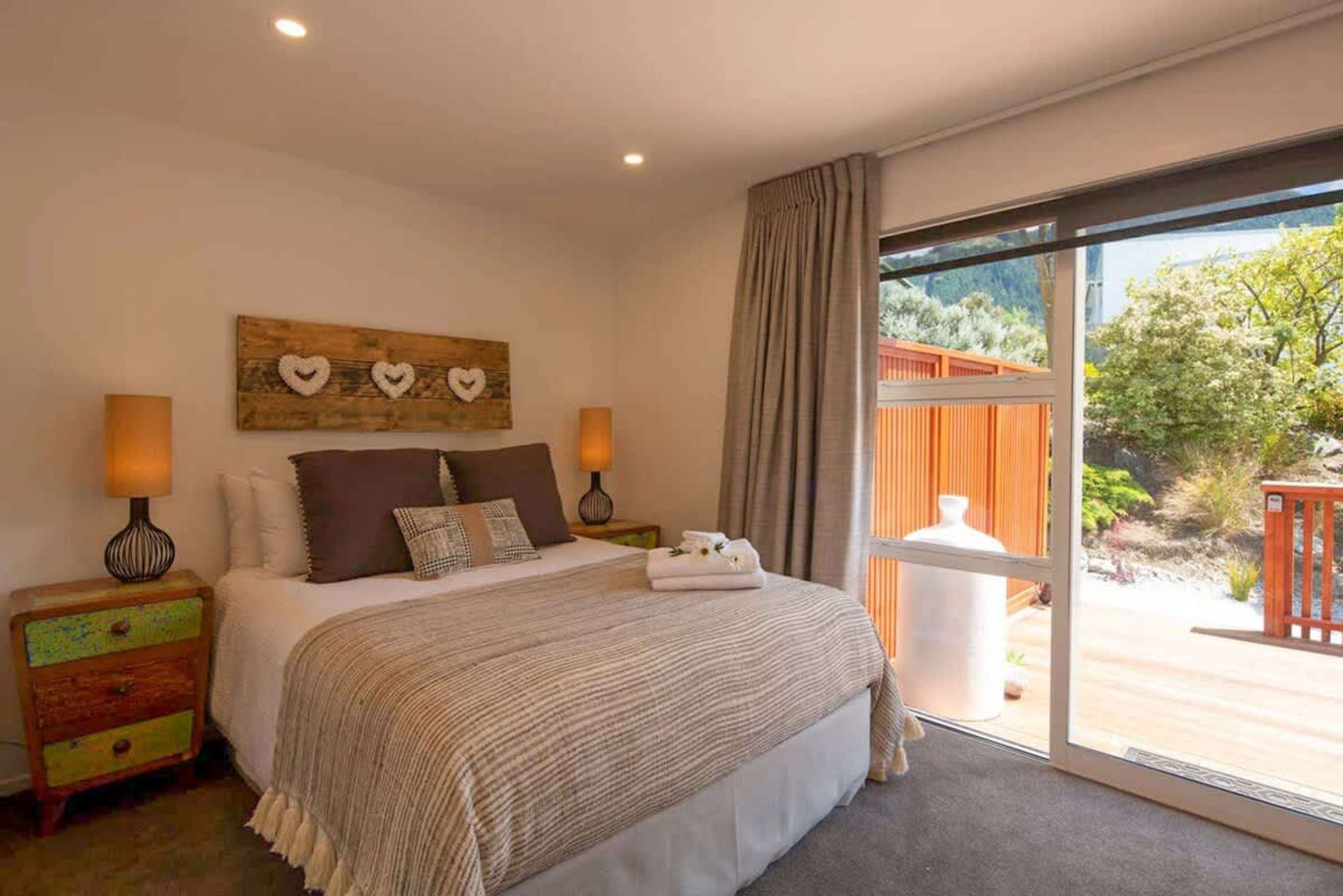 Bedroom with Queen Bed, Ensuite, and Patio Access
This cozy bedroom features a comfortable queen bed, a private ensuite, and direct access to the sunny patio. Enjoy the convenience and relaxation of your own retreat with easy outdoor access.