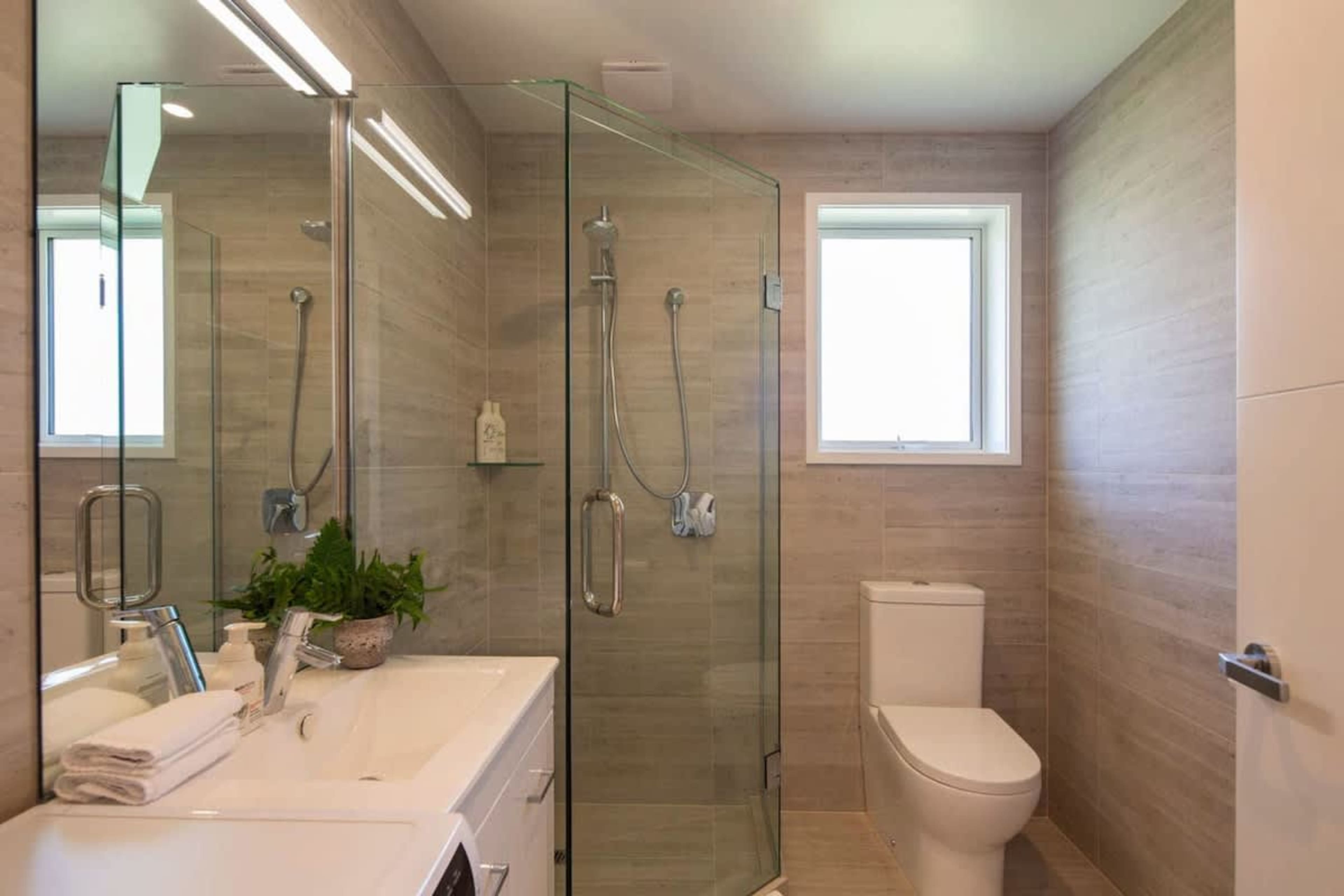 This spacious master bathroom features a walk-in shower, underfloor heating for extra comfort, and is attached to the master bedroom. Designed with luxury in mind, it offers a perfect retreat for relaxation and convenience.