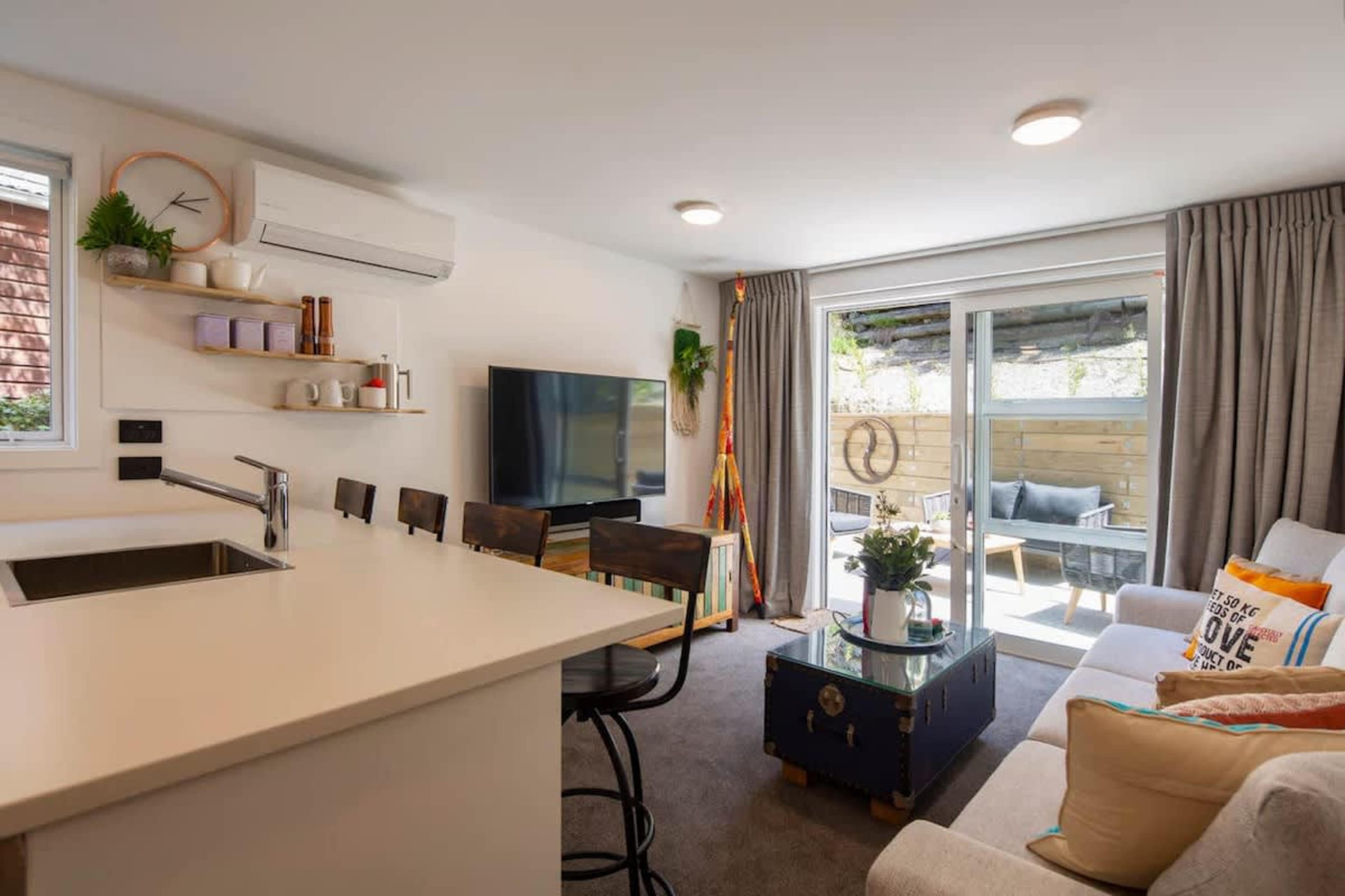 Relax in the bright living room with direct access to the outdoor patio. The perfect space for entertaining or unwinding, with easy flow between the indoors and the sunny, serene patio area.