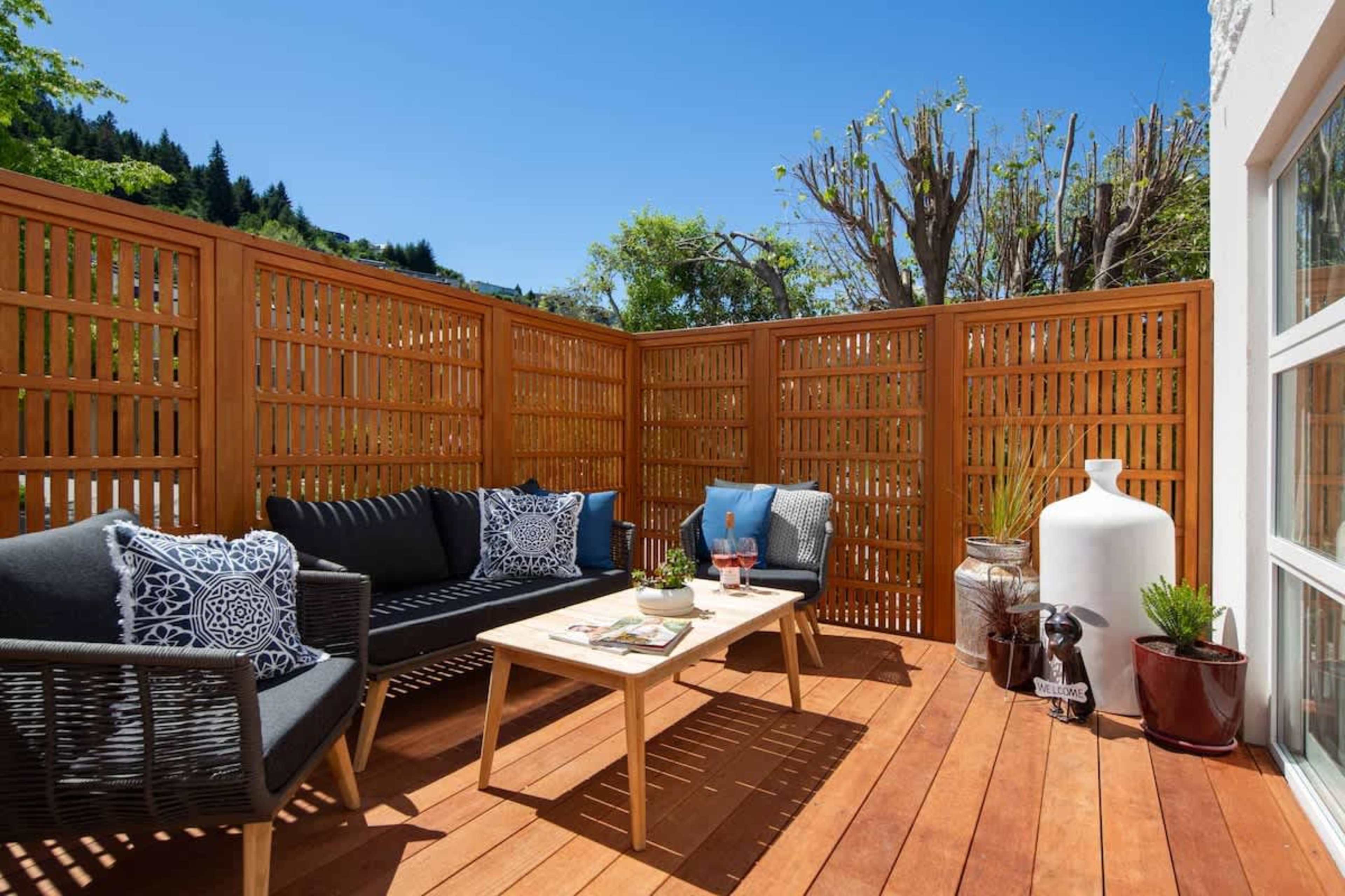 This sunny patio offers seamless indoor-outdoor flow with comfortable seating, perfect for relaxing or enjoying meals. Soak up the sun while taking in the peaceful surroundings, an ideal spot for unwinding throughout the day.