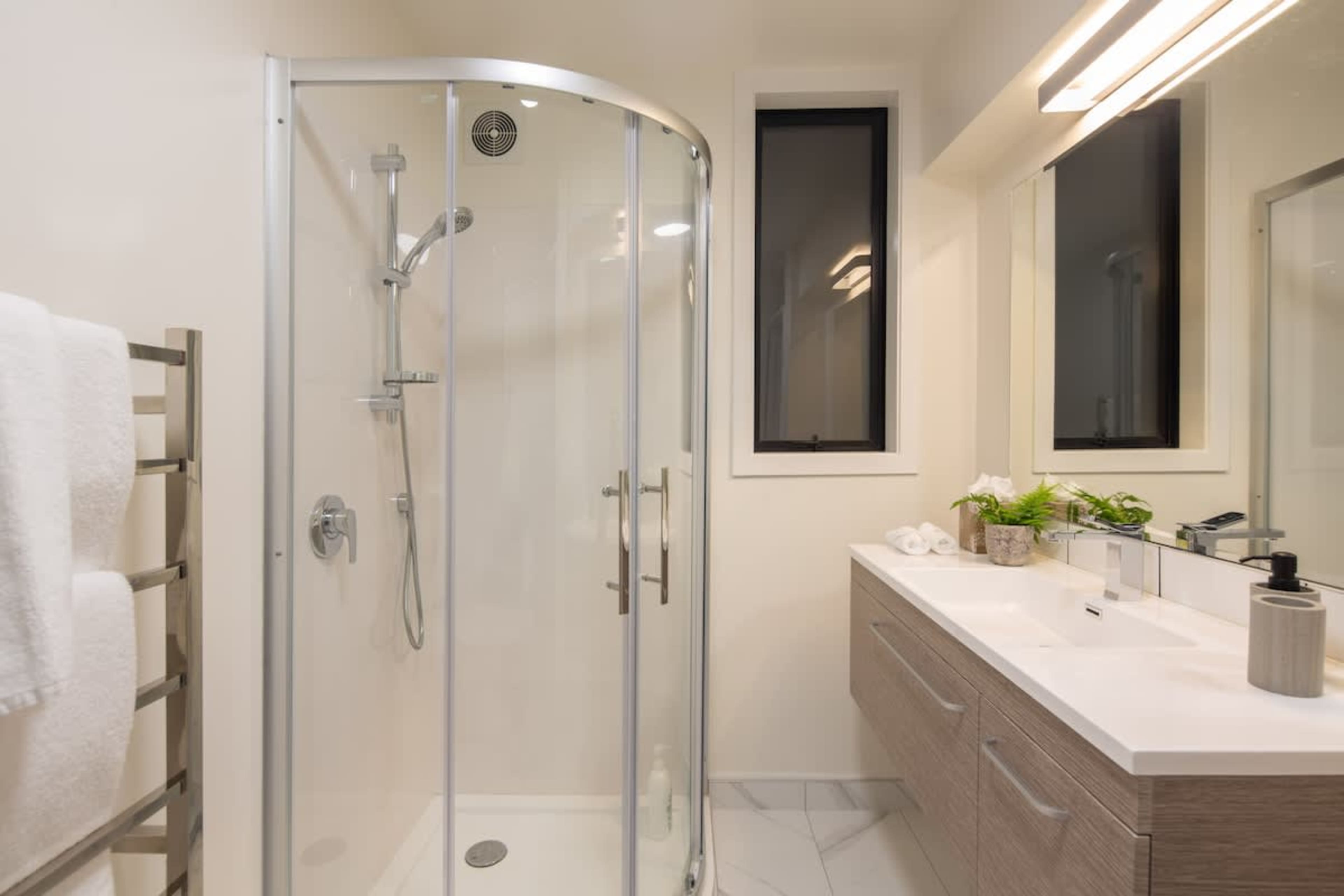 This sleek third bathroom offers a walk-in shower and premium Ashley & Co. toiletries for a touch of luxury. Designed for comfort and style, it provides a refreshing retreat after a day exploring Queenstown.