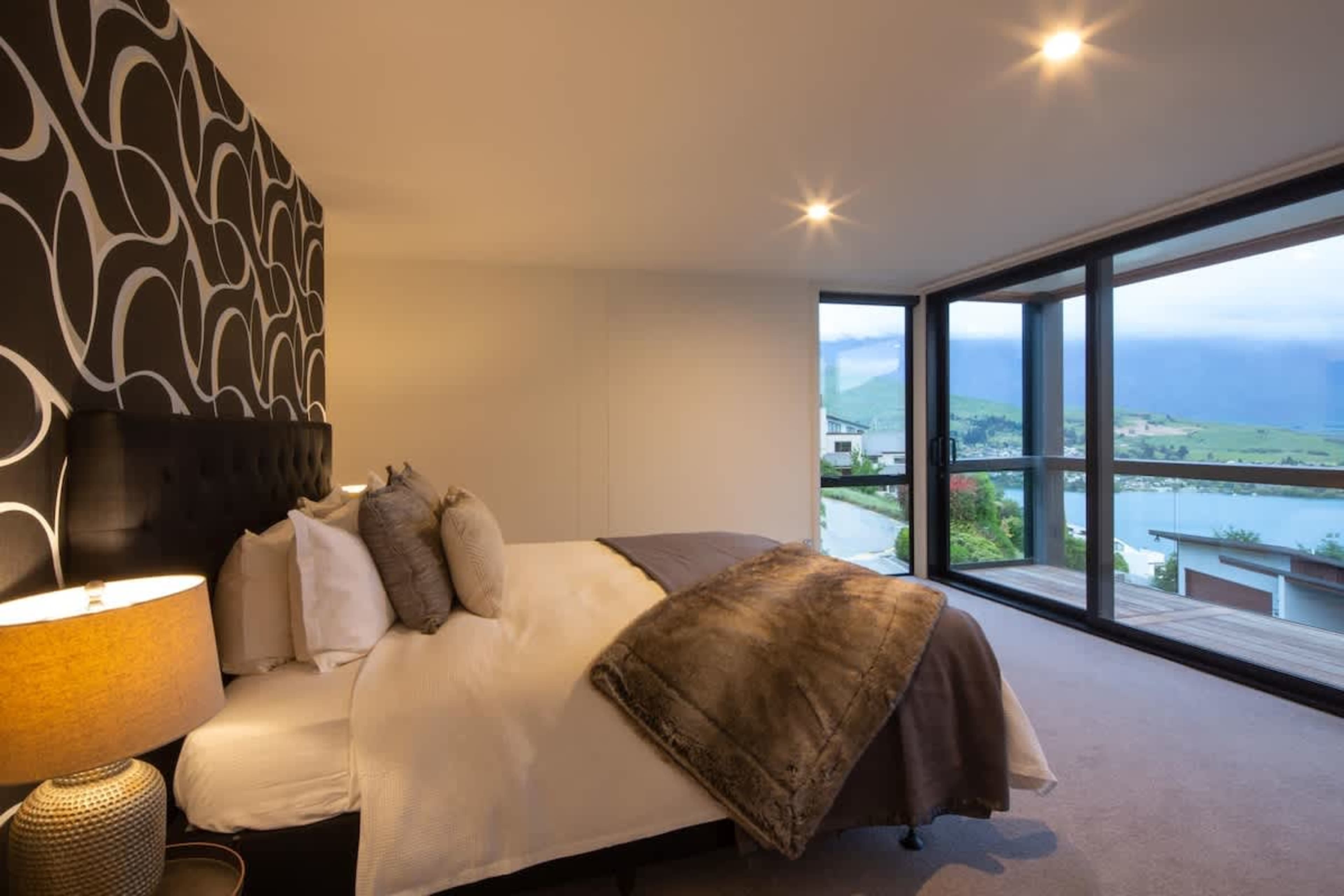 Luxurious Master Bedroom with Views
This spacious master bedroom features a king-sized bed, walk-in wardrobe, and an ensuite with a bathtub and walk-in shower. Enjoy stunning views of Lake Wakatipu and the Remarkables.