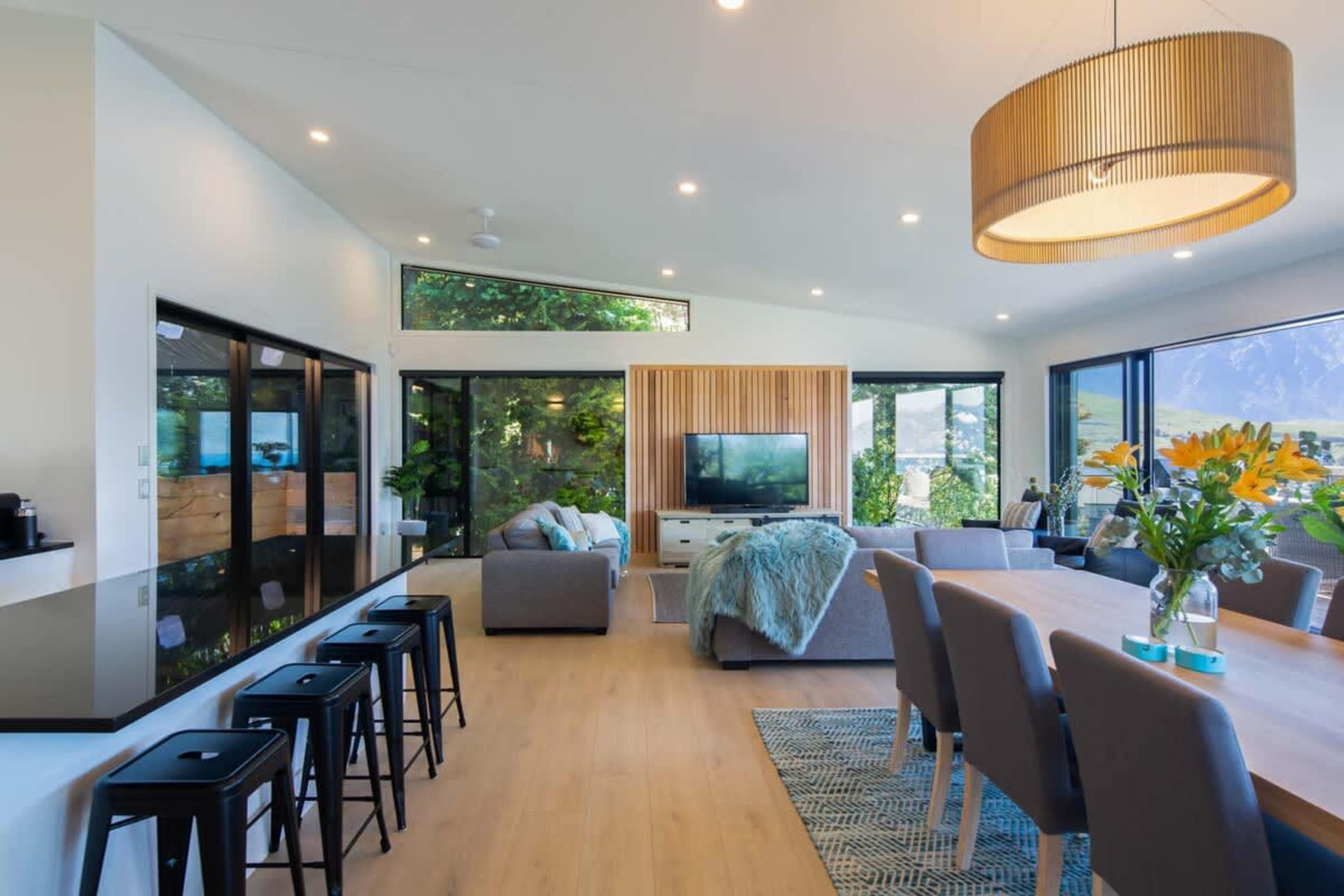 Elegant Dining Room with Stunning Views
This dining room offers a spacious setting with large windows showcasing breathtaking views of Lake Wakatipu and the Remarkables. With a sleek dining table it's the perfect place for memorable moments.
