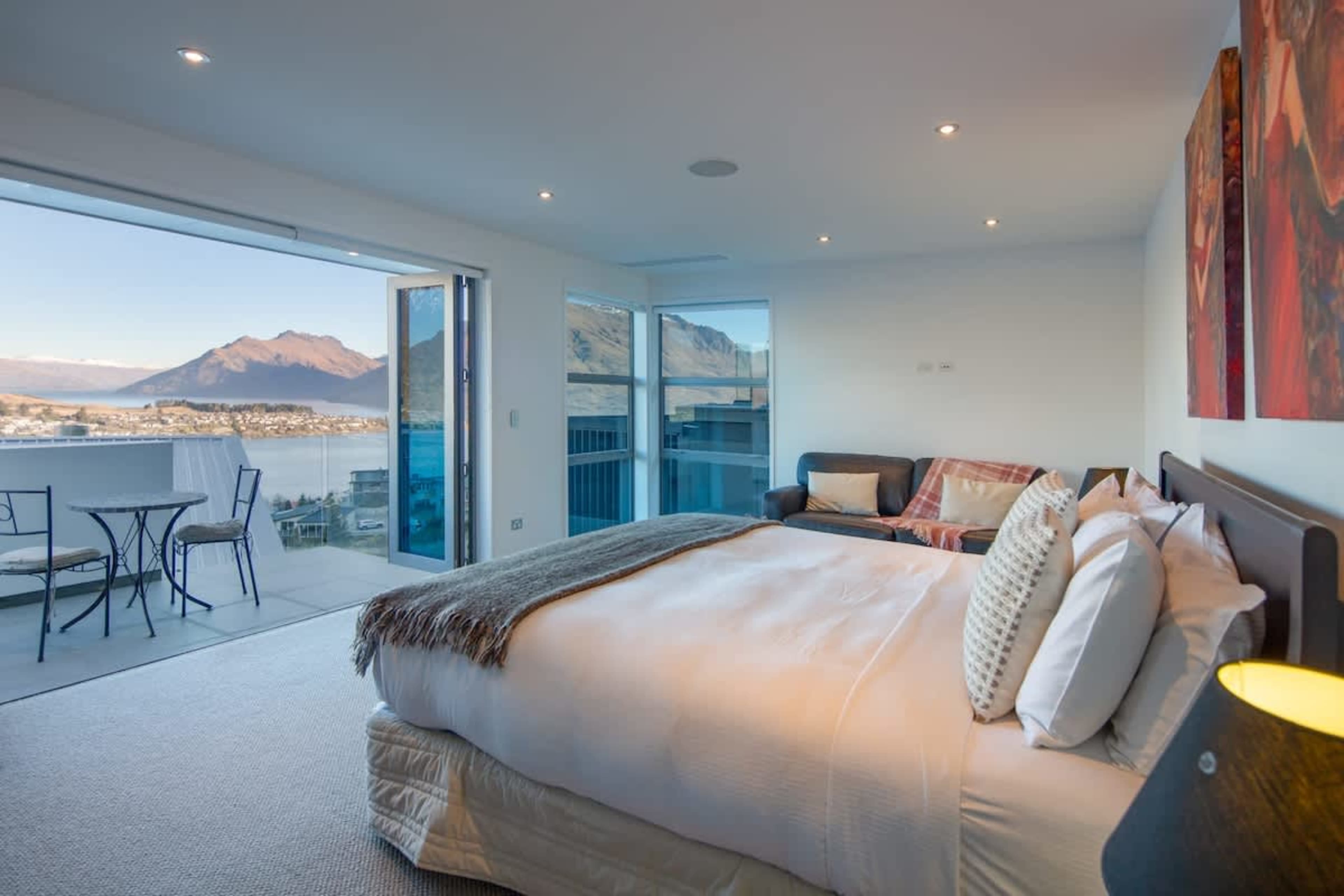 Elegant Master Bedroom with Private Balcony – Relax in a luxurious suite with a plush bed and direct access to a private balcony, perfect for enjoying morning coffee with breathtaking views of Lake Wakatipu.