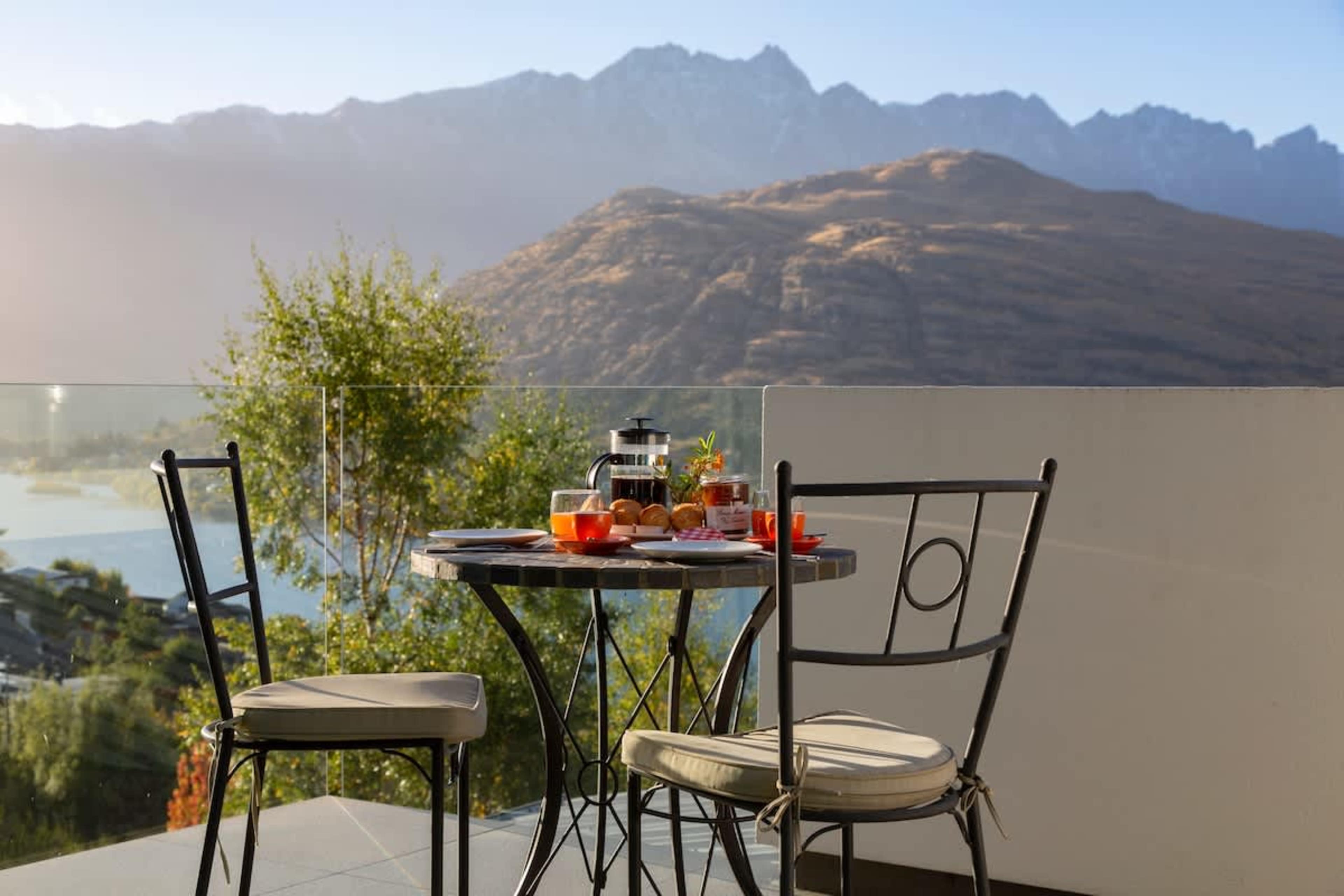 Master Bedroom Private Patio with Breathtaking Views – Step out onto a serene private patio with a cozy table, perfect for breakfast or a glass of wine, while enjoying stunning views of the lake and mountains.
