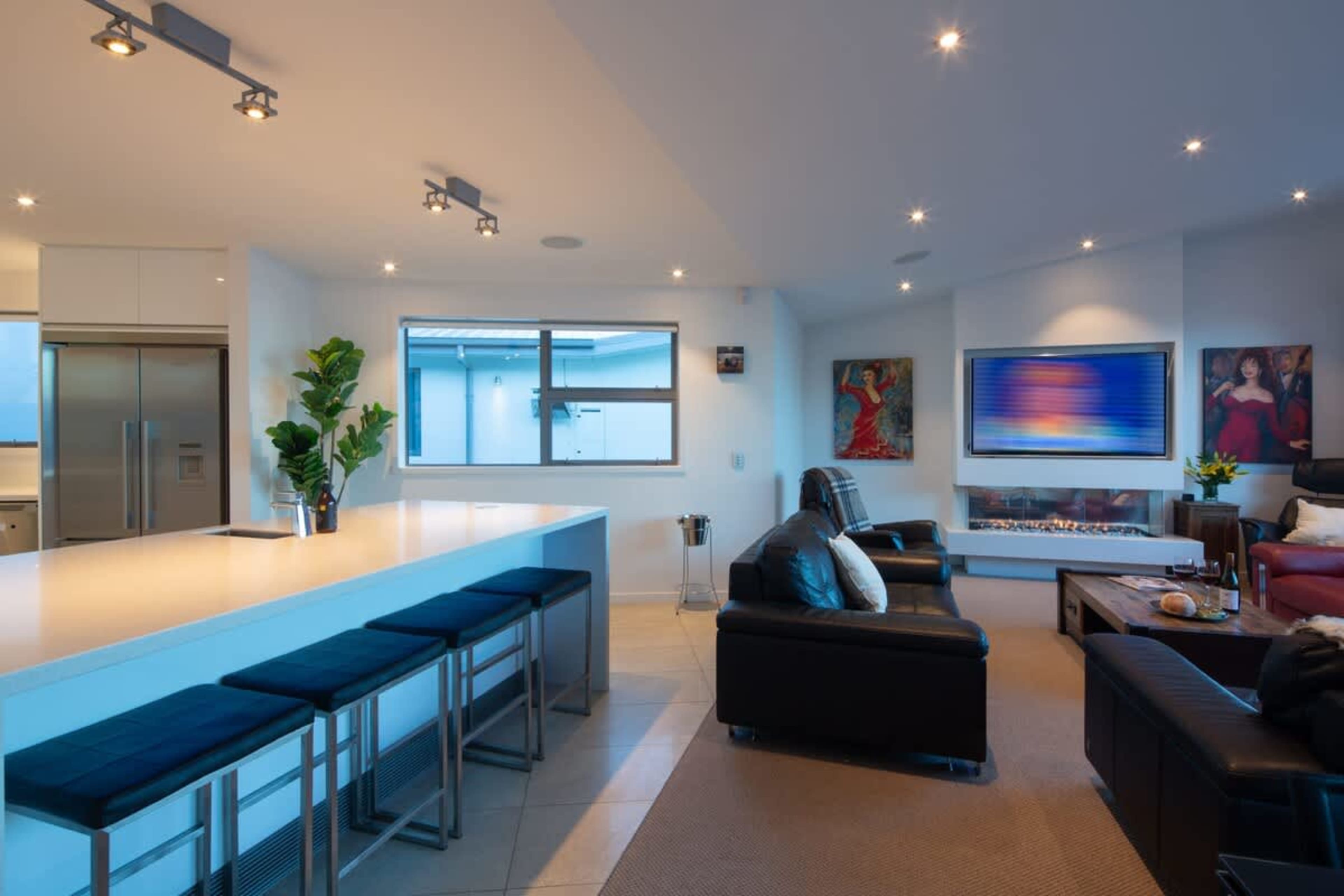 Bright and Stylish Living Room – A perfect blend of comfort and elegance, featuring expansive windows, modern furnishings, and breathtaking views of Lake Wakatipu and The Remarkables.