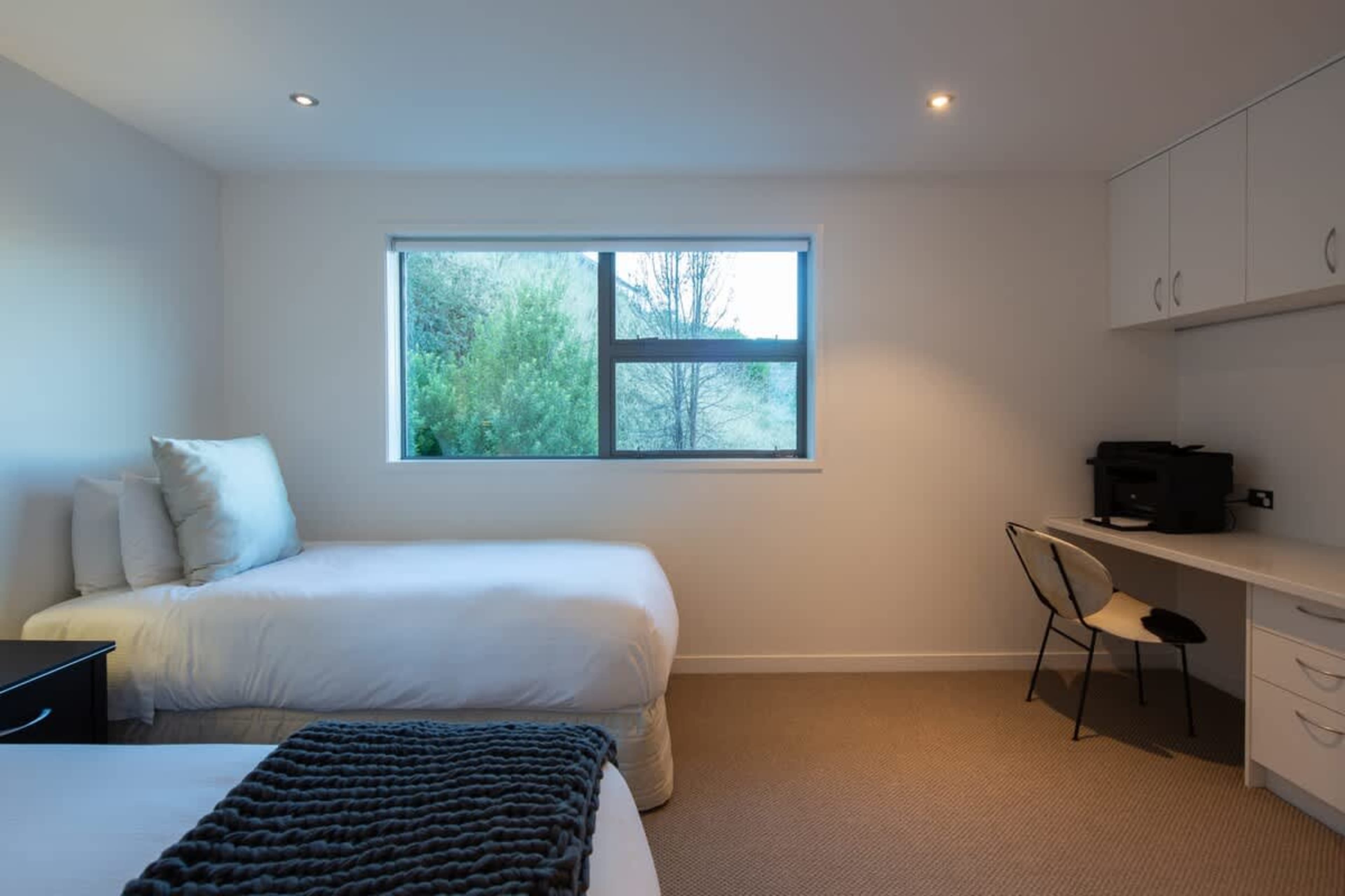 Stylish Second Bedroom with Work Station – This beautifully appointed second bedroom combines comfort and functionality, featuring plush bedding and a dedicated desk/work station, perfect for relaxing or getting some work done.