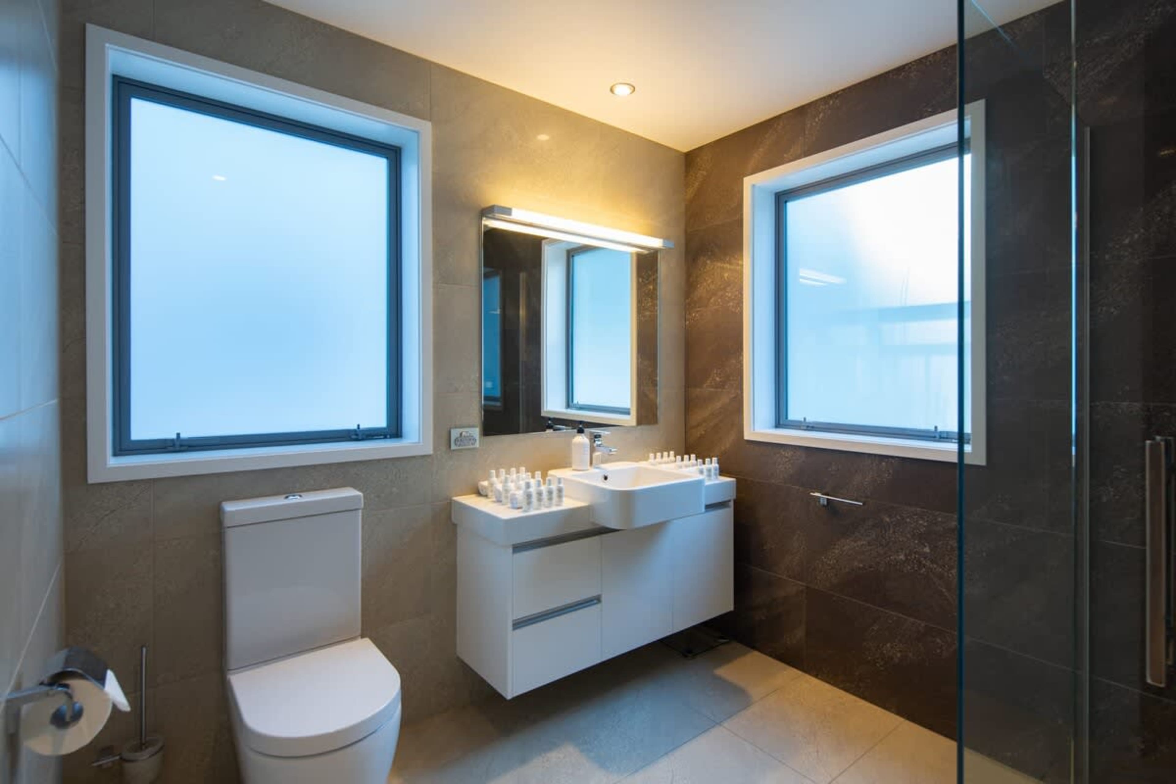 Sleek Bathroom with Walk-In Shower and Unlimited Hot Water – Experience the luxury of a spacious walk-in shower with unlimited hot water, complemented by premium finishes and underfloor heating for your comfort.
