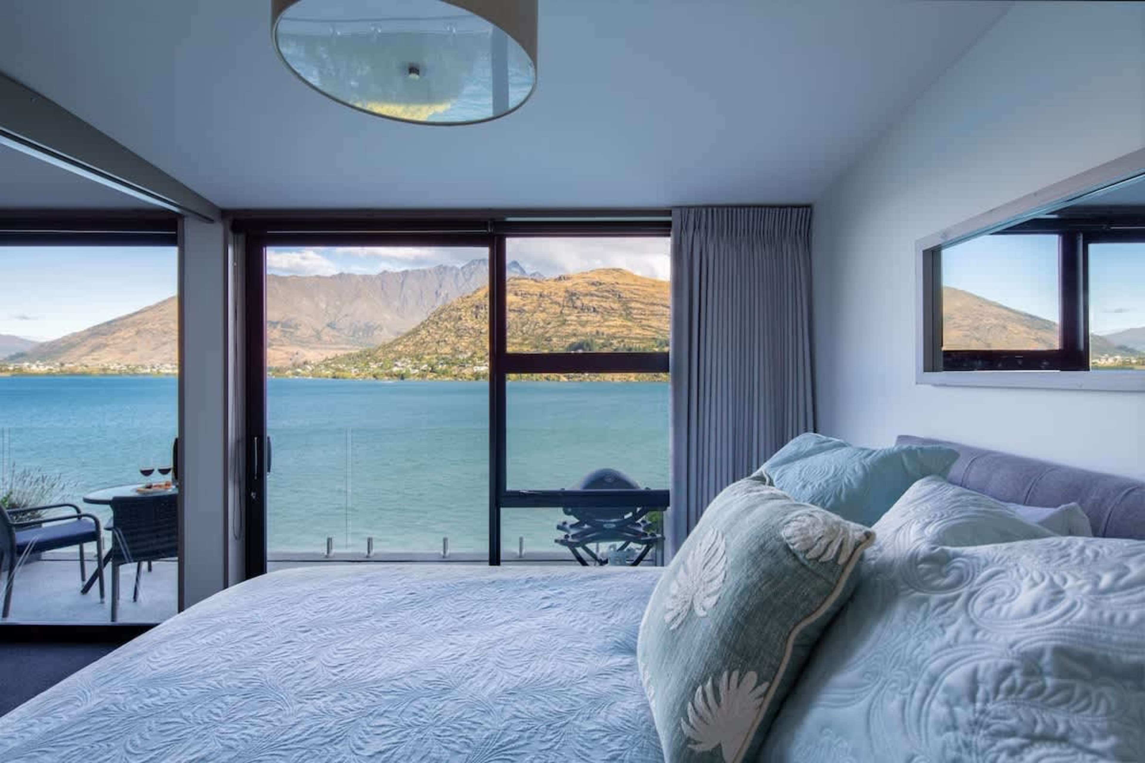 Tranquil Bedroom with Lake Views – Drift off to sleep in this serene bedroom featuring a comfortable queen bed and expansive windows offering stunning lakefront views.