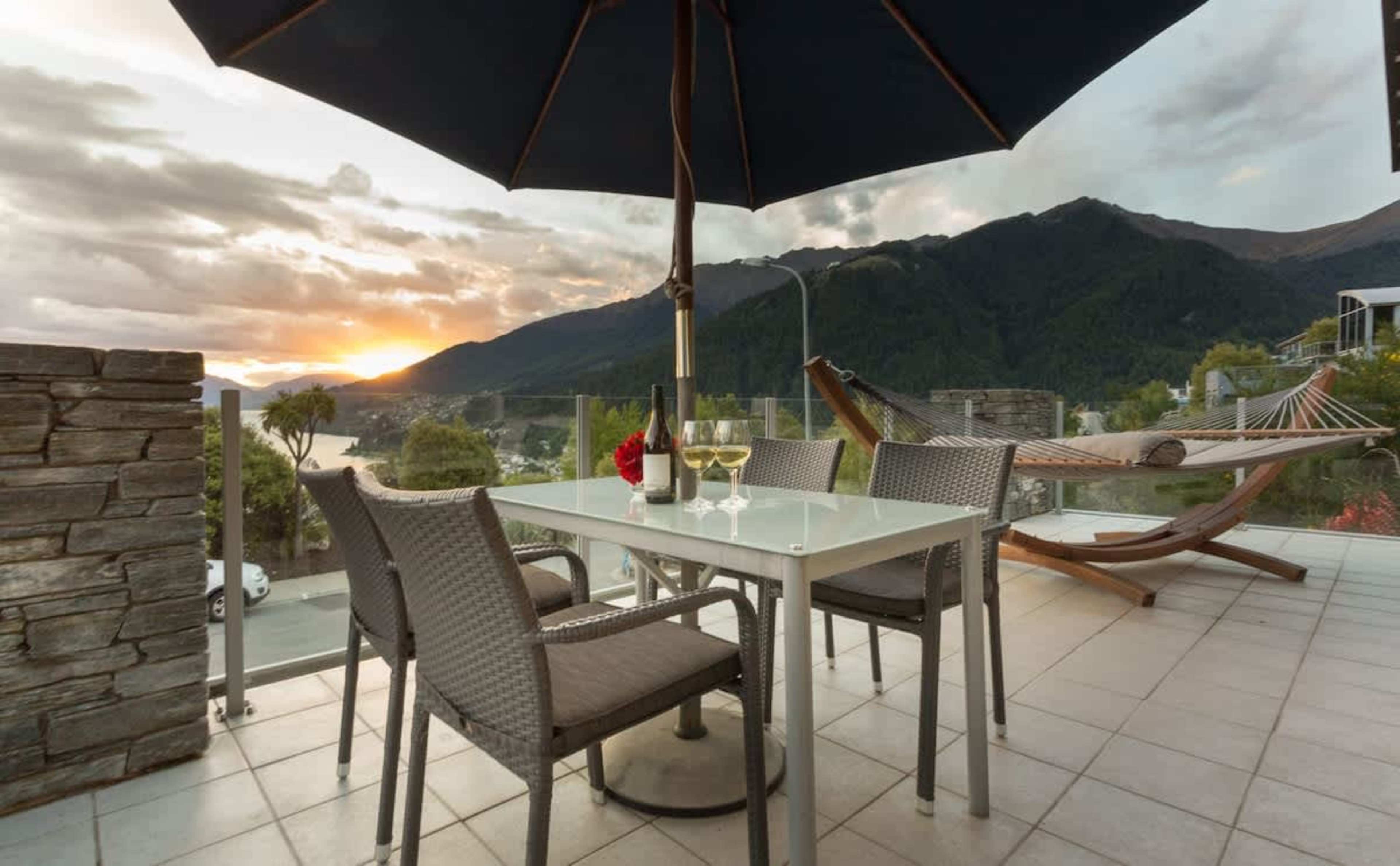 Enjoy dinner at an outdoor dining table with a sunset view at our holiday apartment in Queenstown