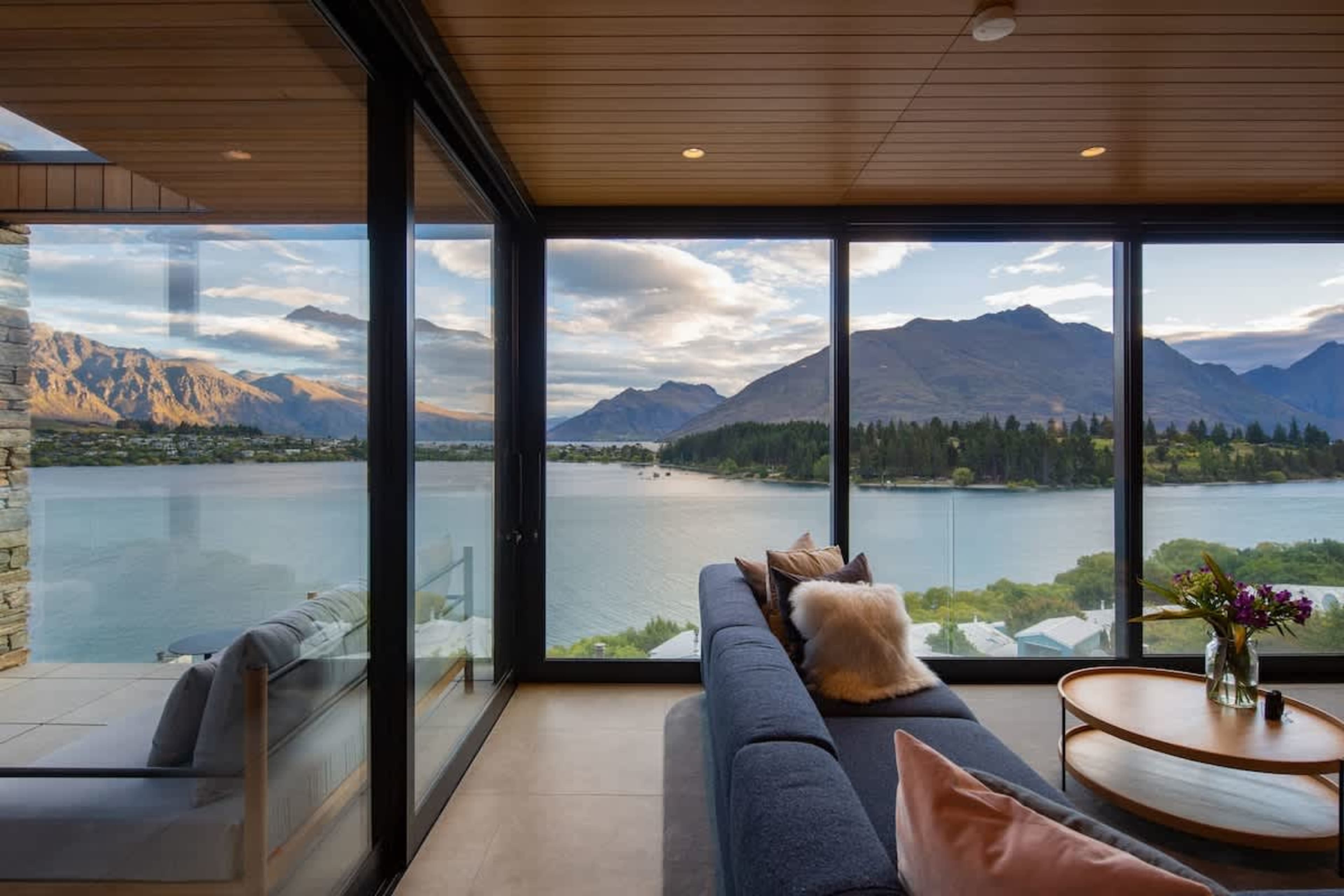 
Luxurious Living Area with Fireplace – Relax in this spacious living room, featuring a stylish fireplace and panoramic views of Lake Wakatipu and Queenstown's stunning landscape, perfect for unwinding in any season.
