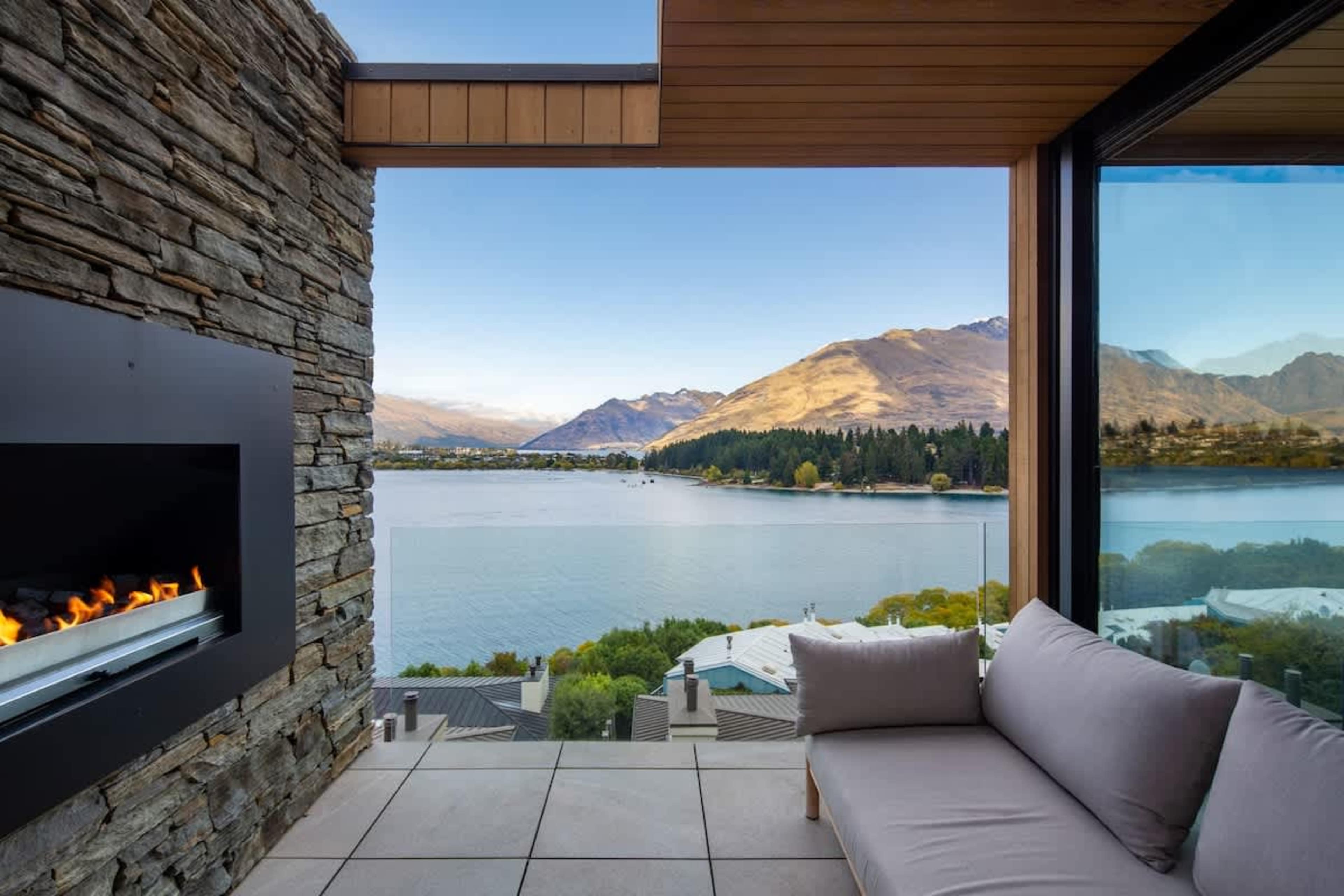 Patio Retreat with Fireplace and Views – Unwind on the patio by the flickering fireplace, surrounded by panoramic views of the lake, creating an ideal spot for both relaxation and entertainment.