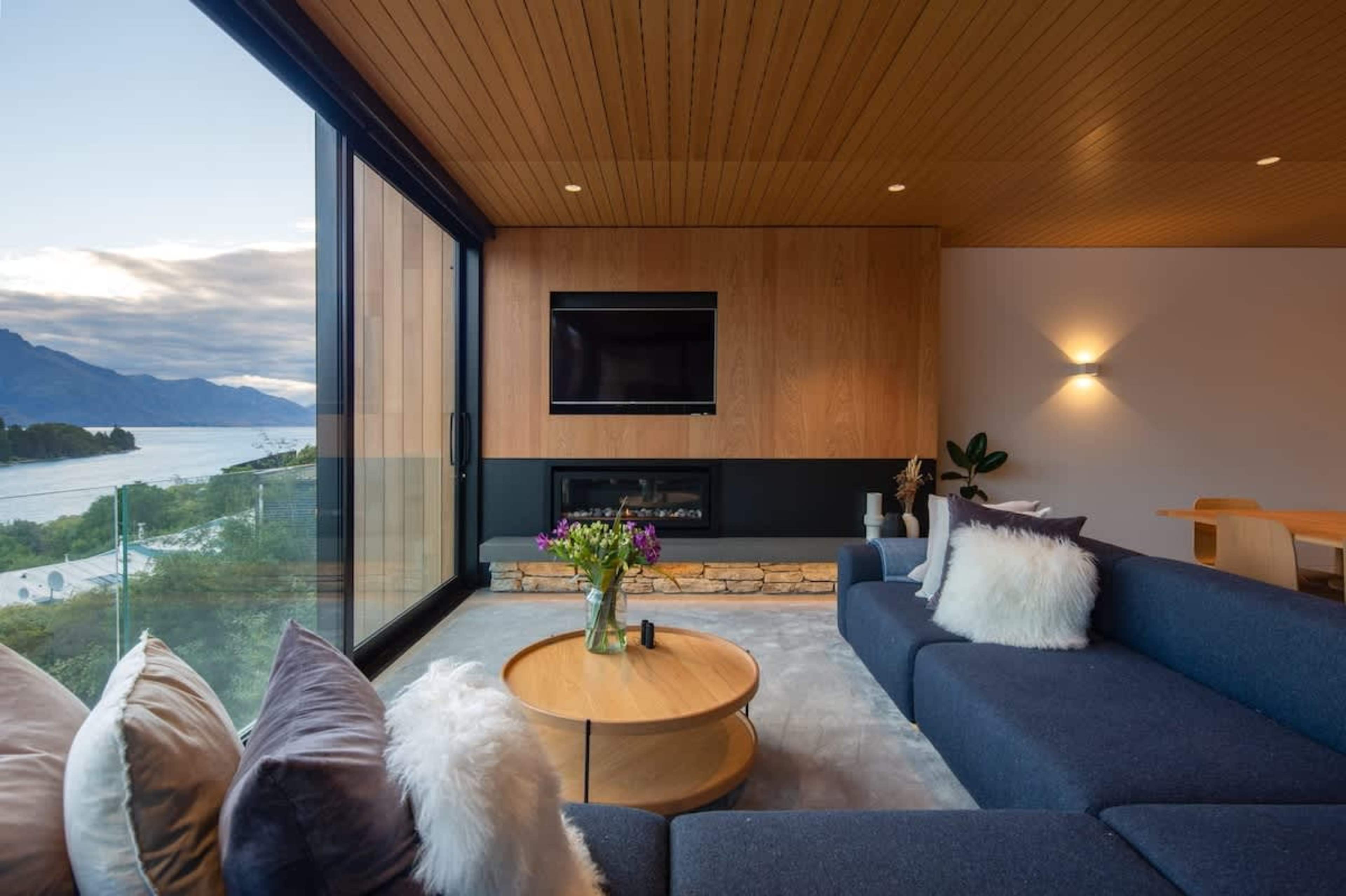 Spacious Living Room with Fireplace – Featuring a large, inviting fireplace, this living room offers the perfect space to relax, with sweeping views of the lake and surrounding scenery.