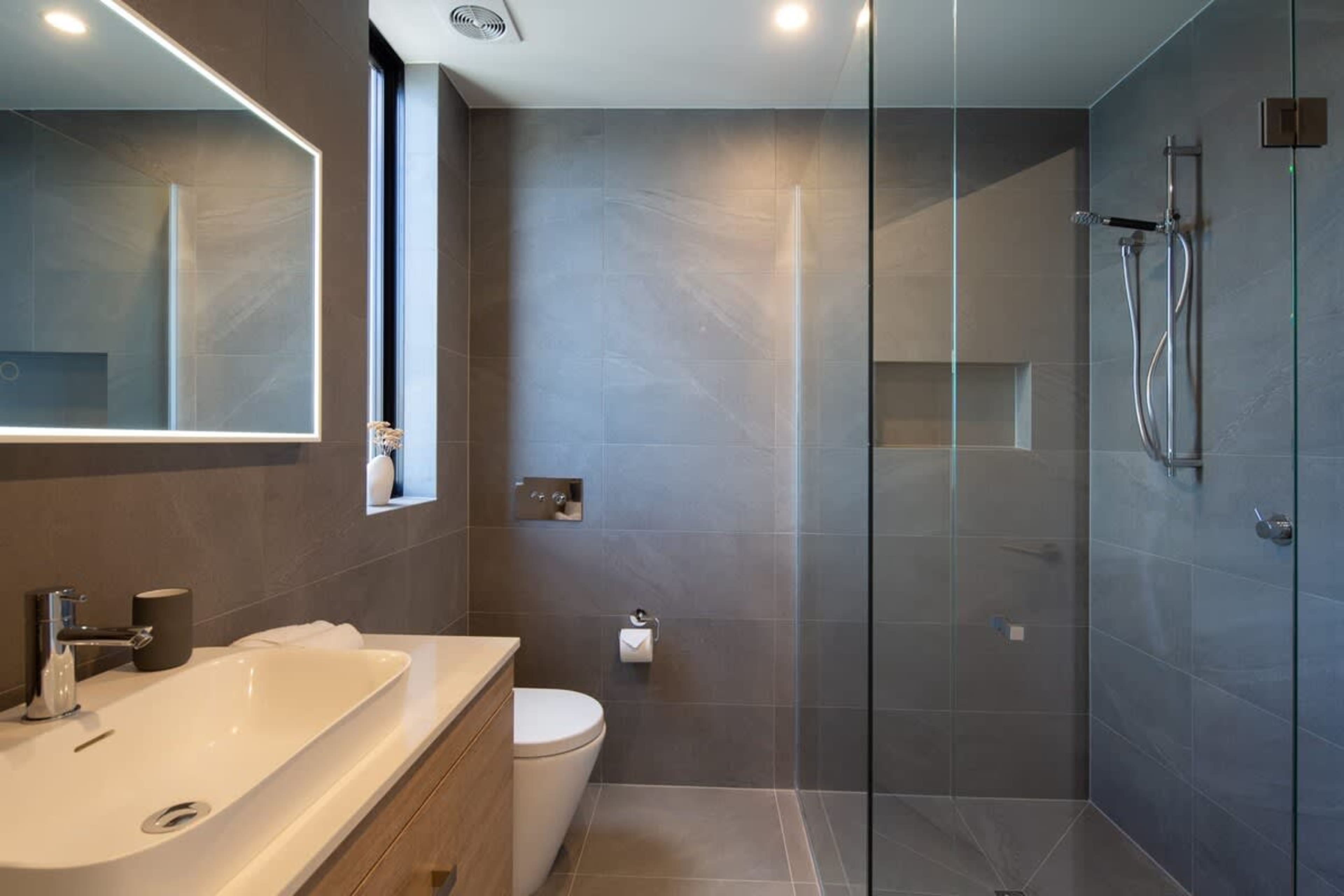 Stylish Second Bathroom – This modern bathroom features a spacious shower, sleek fixtures, and Ashley & Co toiletries, offering both functionality and a touch of luxury.