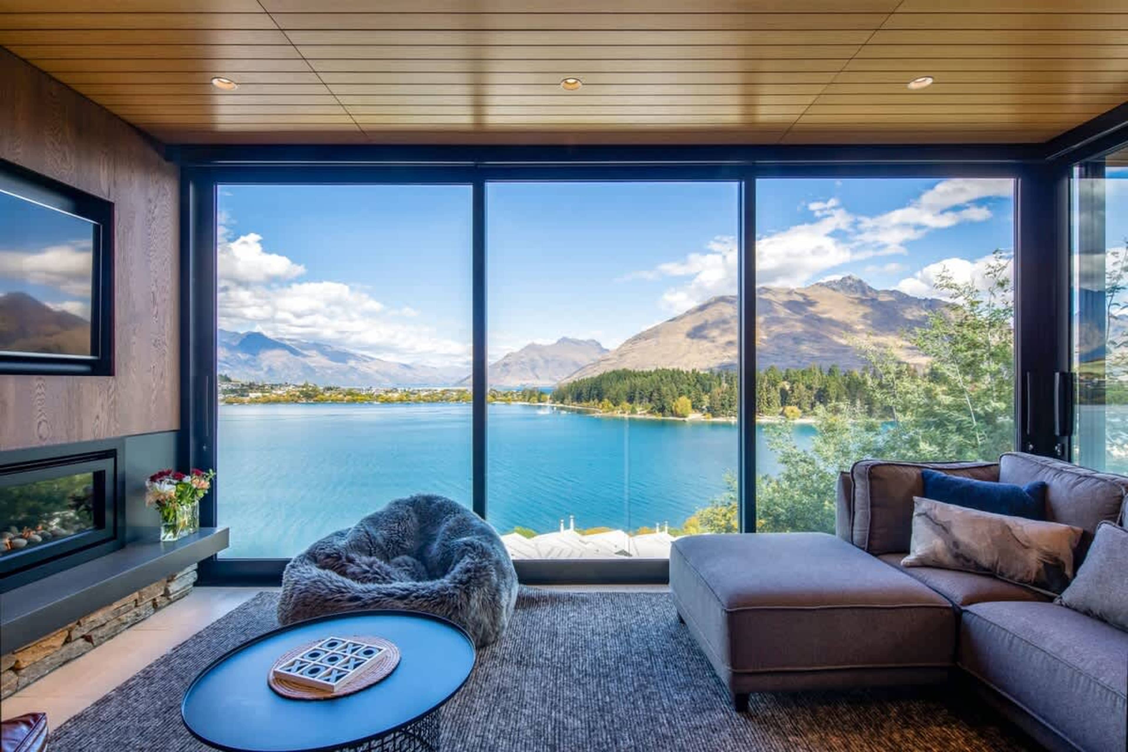 Elegant Living Area with Stunning Lake Views – This open-plan living room combines sophisticated decor and comfortable seating, with direct views of Lake Wakatipu, creating an ideal space for both relaxation and entertaining in Queenstown.