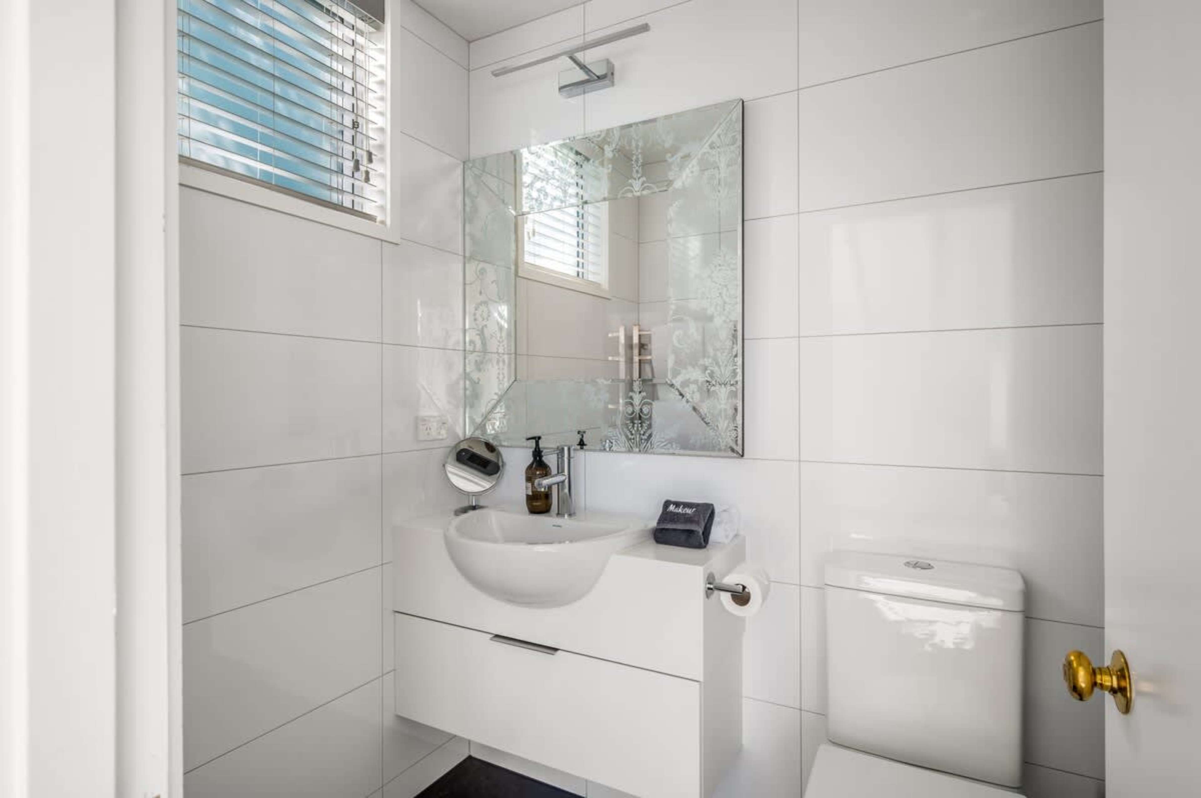 Relax in the stylish second bathroom, featuring heated floors, premium Ashley & Co. toiletries, and high-quality linen for ultimate comfort.